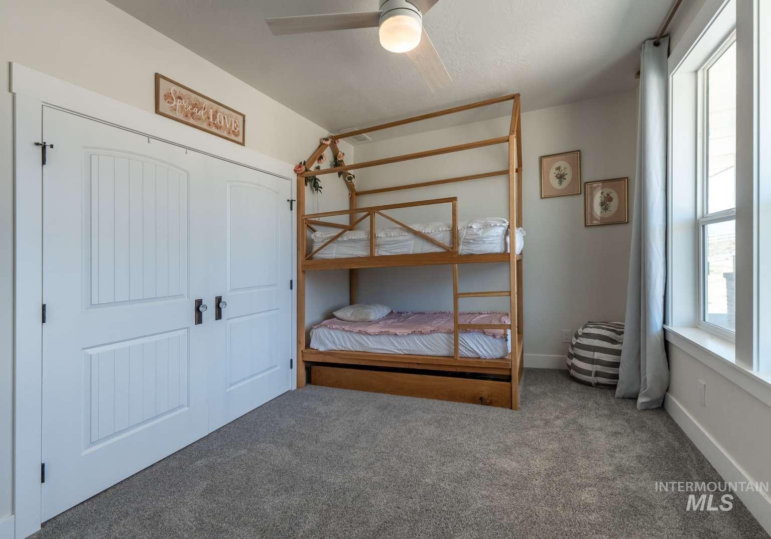 Bedroom with carpet flooring, a ceiling fan, and a closet
