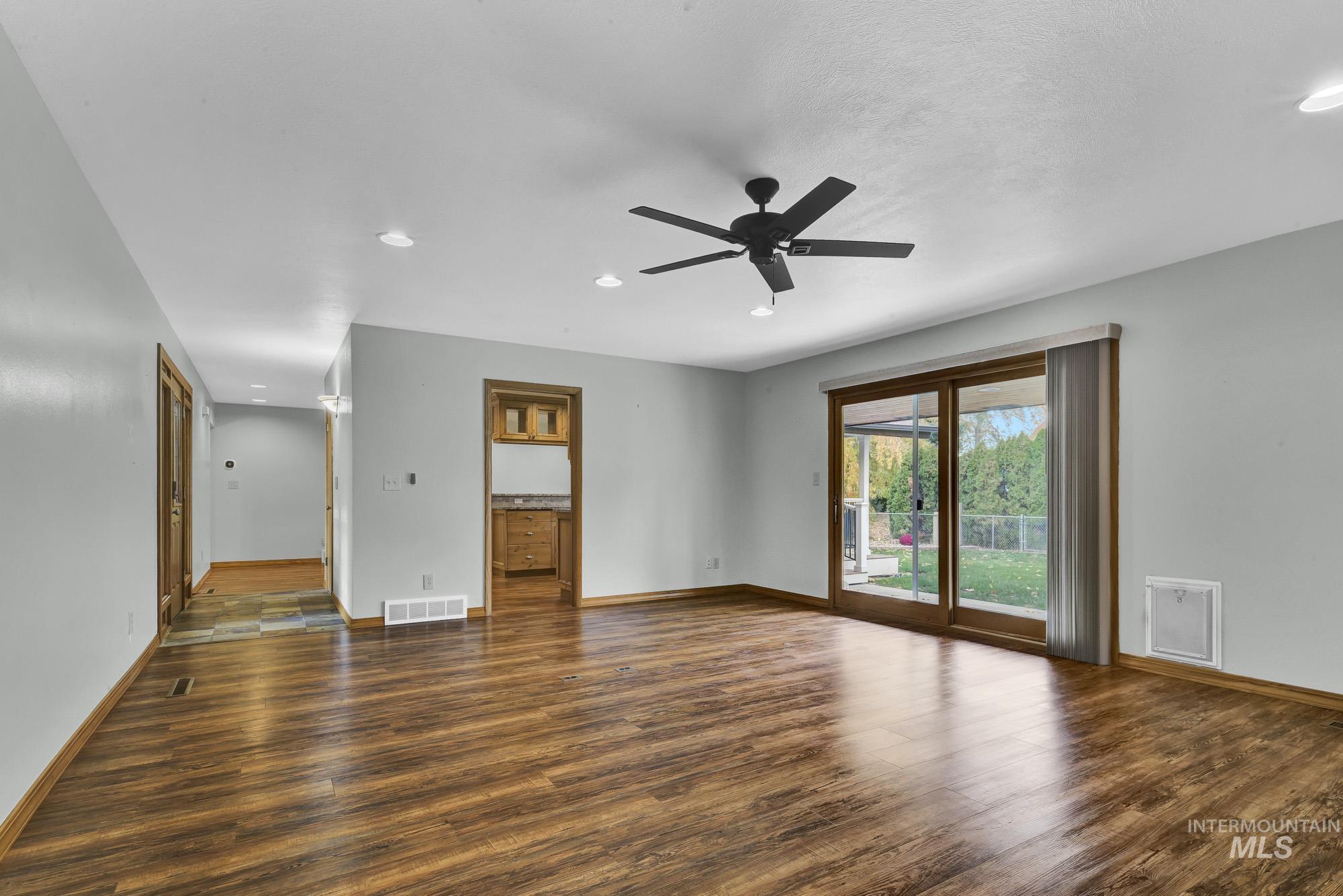 Empty room with dark wood-style floors, recessed lighting, and ceiling fan