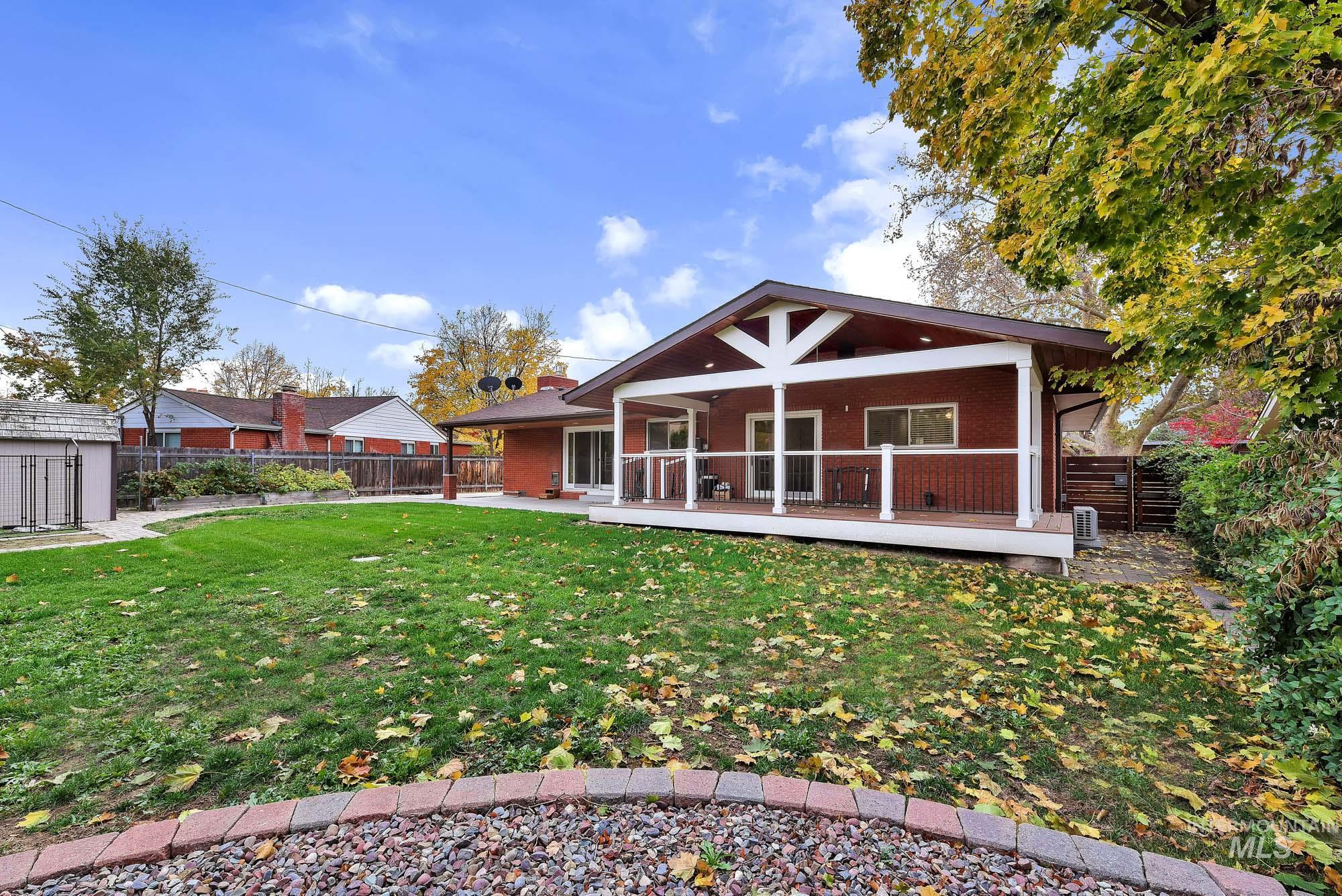 Back of property with a fenced backyard, brick siding, and ceiling fan