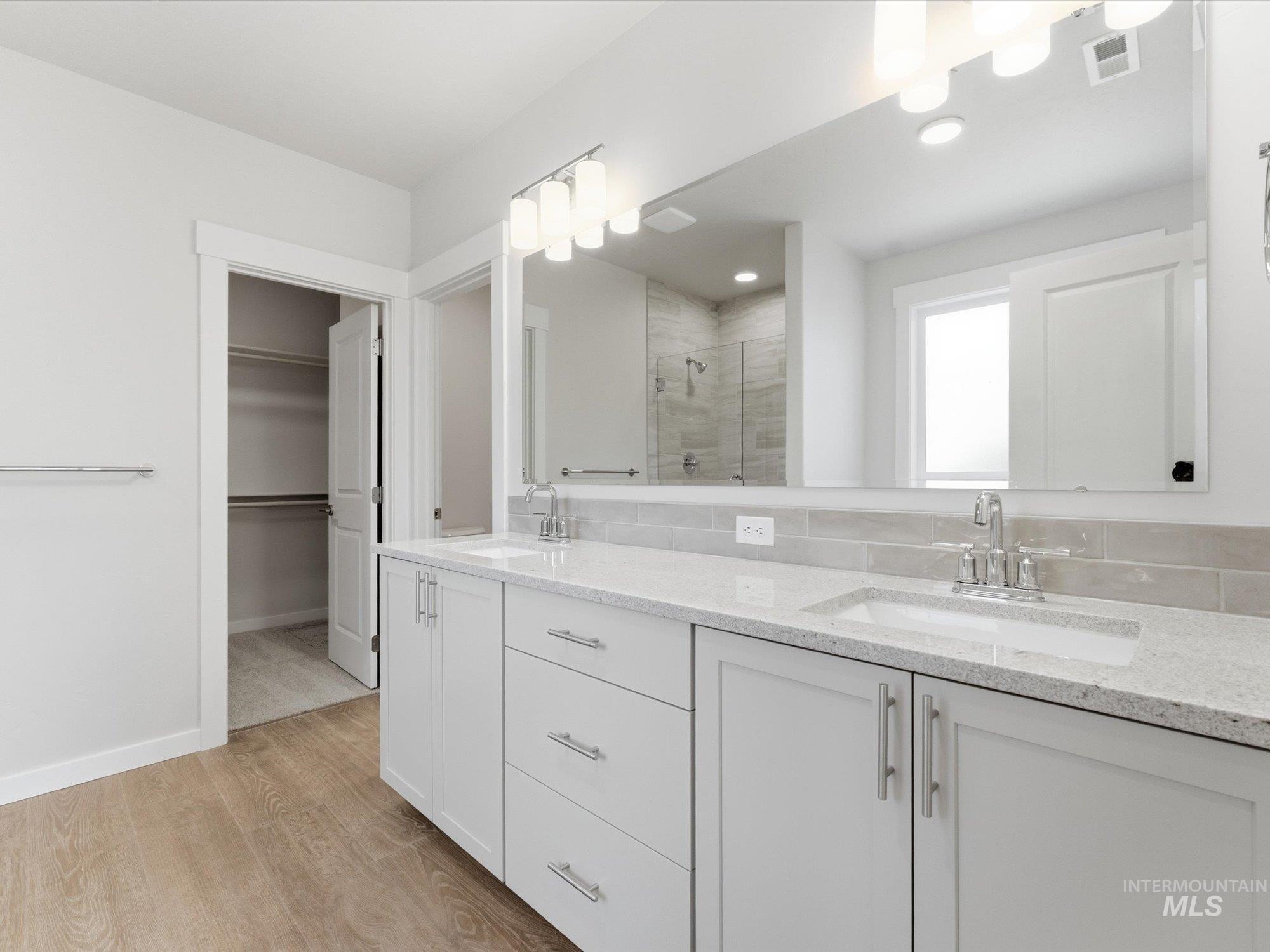 Double vanity featuring quartz countertops, undermount sinks, and chrome fixtures
