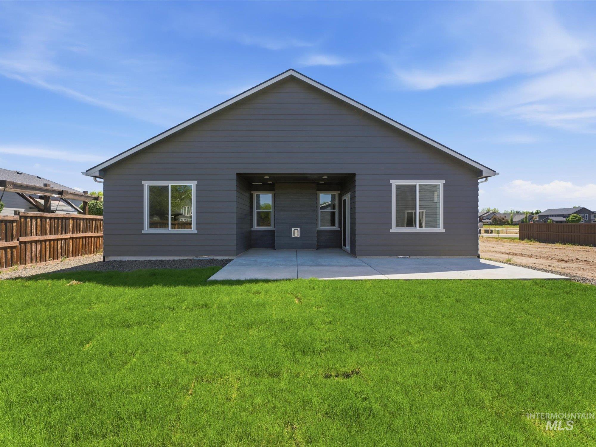 Rear elevation featuring gray horizontal siding, a gabled roofline, and multiple windows with white trim