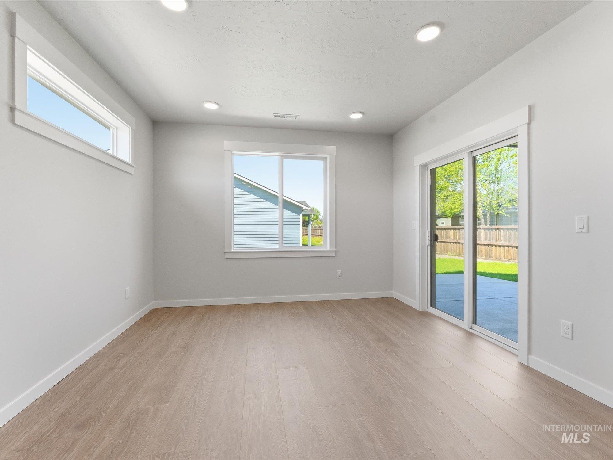 Open-concept room featuring light wood-finish flooring and recessed lighting