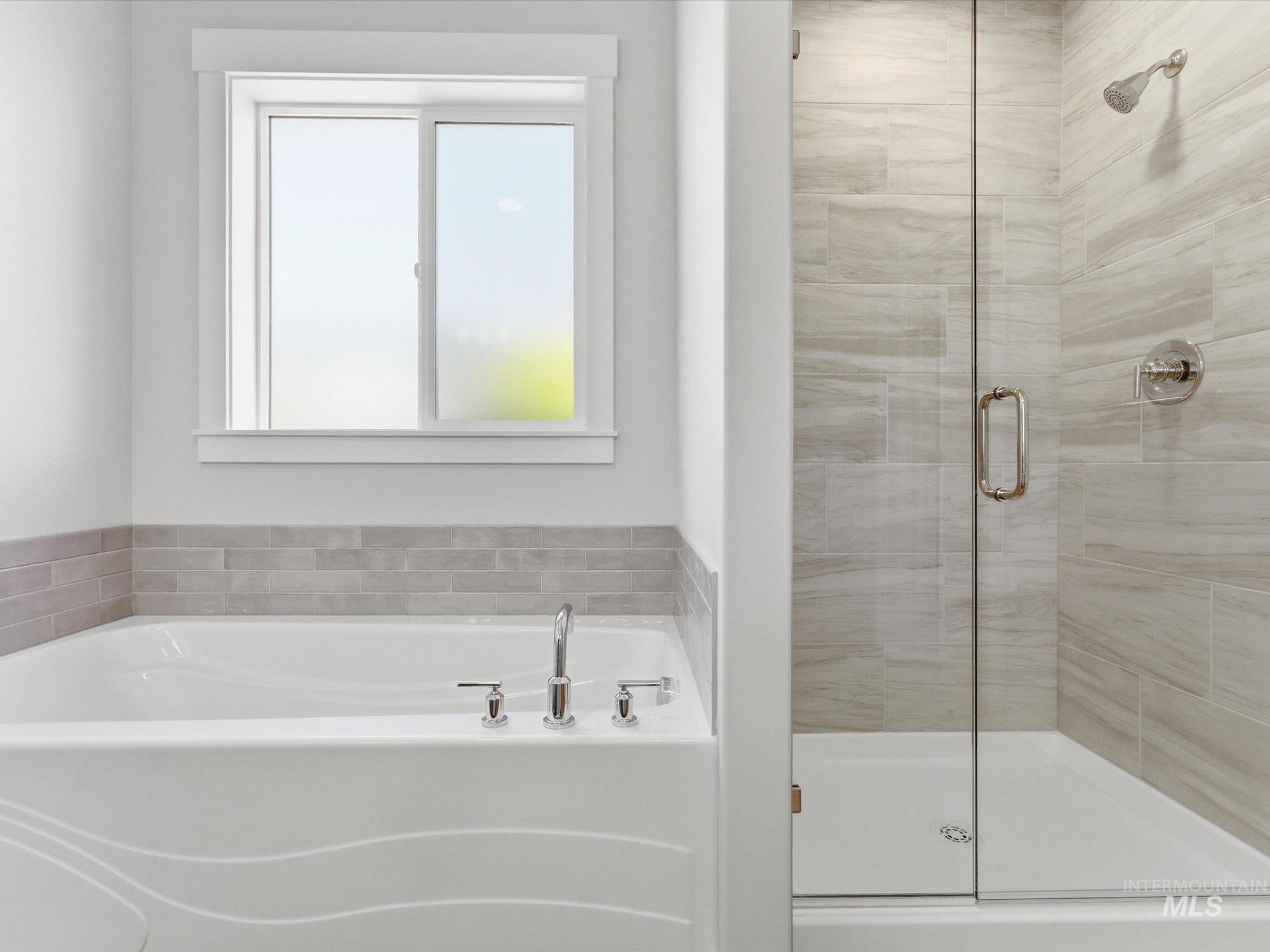 Soaking tub with deck-mounted faucet and a tiled surround