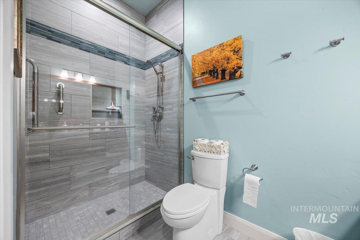 Full bathroom featuring toilet and a stall shower