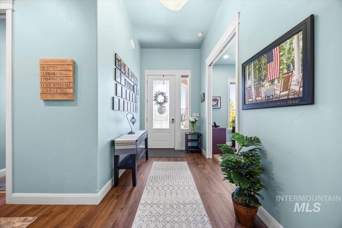 Foyer entrance with baseboards and dark wood-style flooring