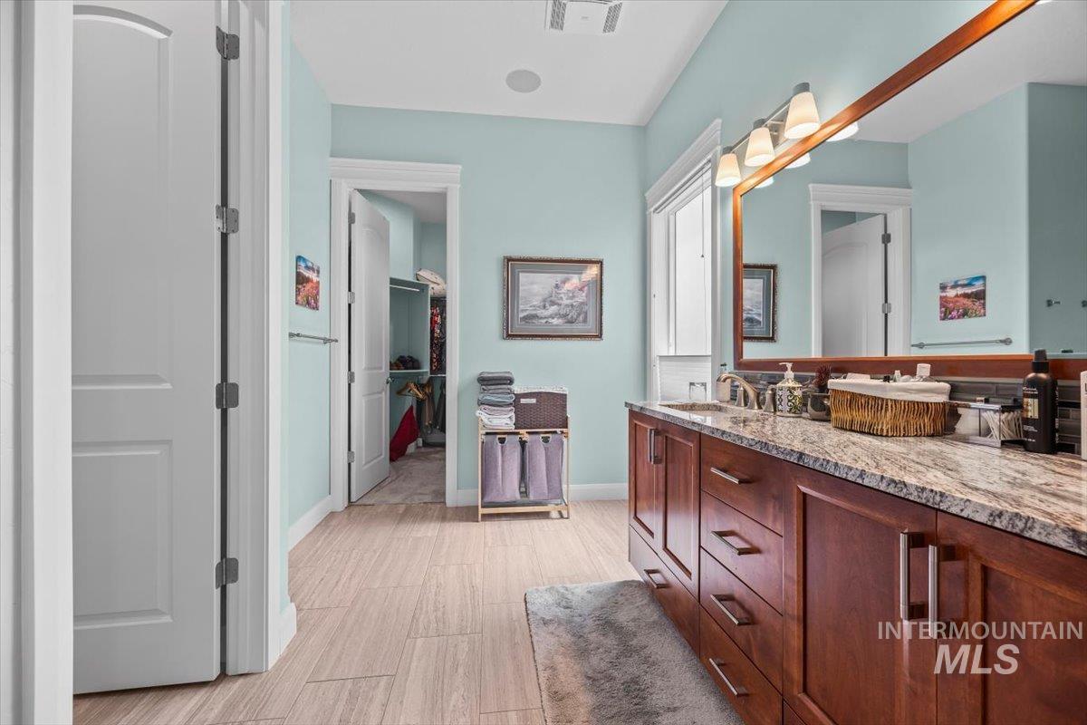 Full bathroom with double vanity and light wood-style floors