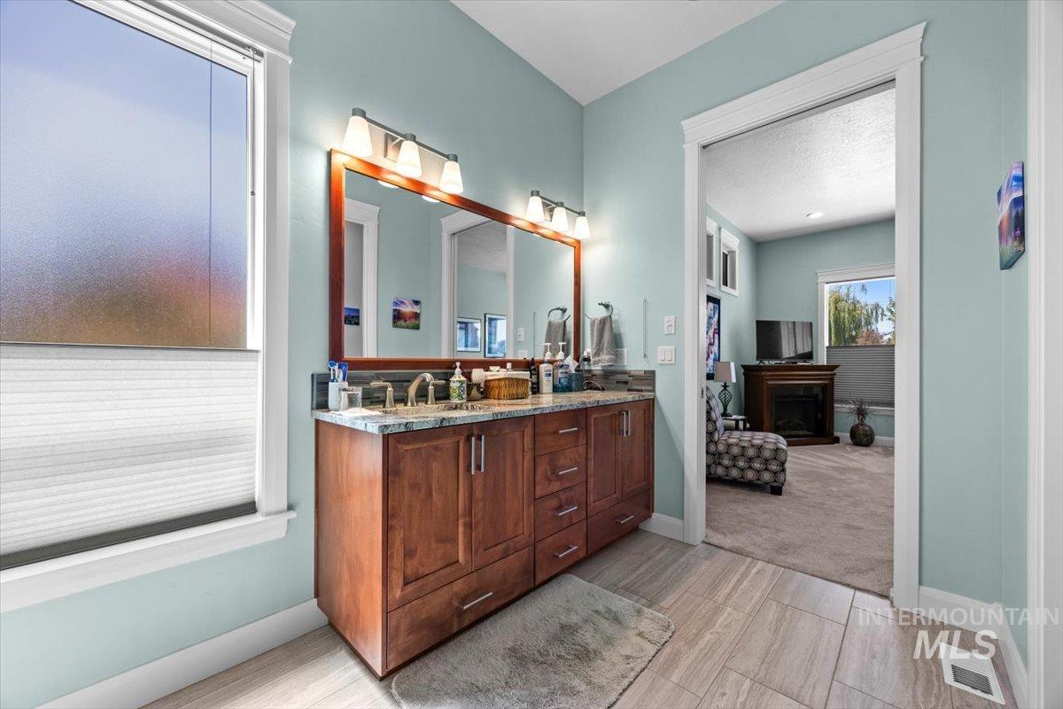 Ensuite bathroom featuring double vanity and a fireplace