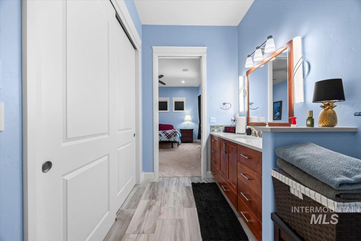 Ensuite bathroom featuring vanity and light wood-type flooring