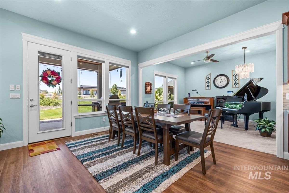 Dining area with dark wood-style floors, a chandelier, recessed lighting, and a ceiling fan
