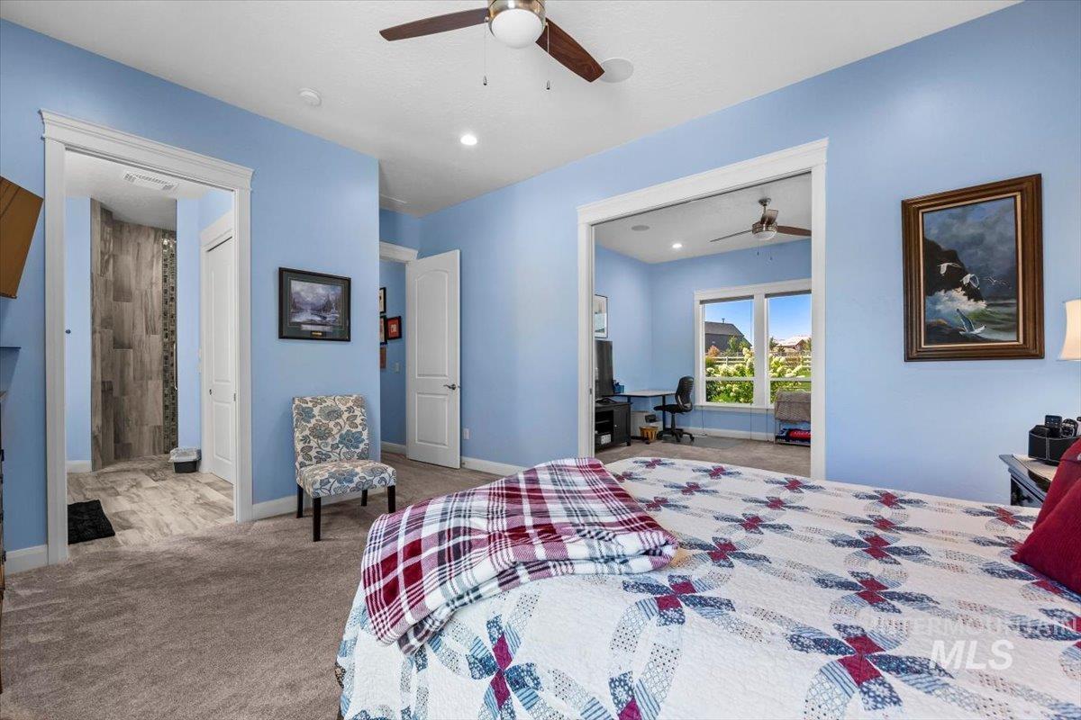 Carpeted bedroom featuring ceiling fan, a desk, and recessed lighting
