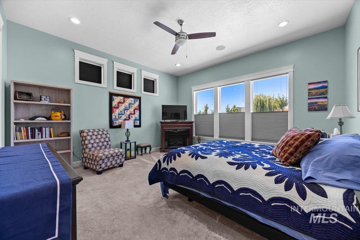 Bedroom with carpet flooring, a textured ceiling, ceiling fan, and recessed lighting