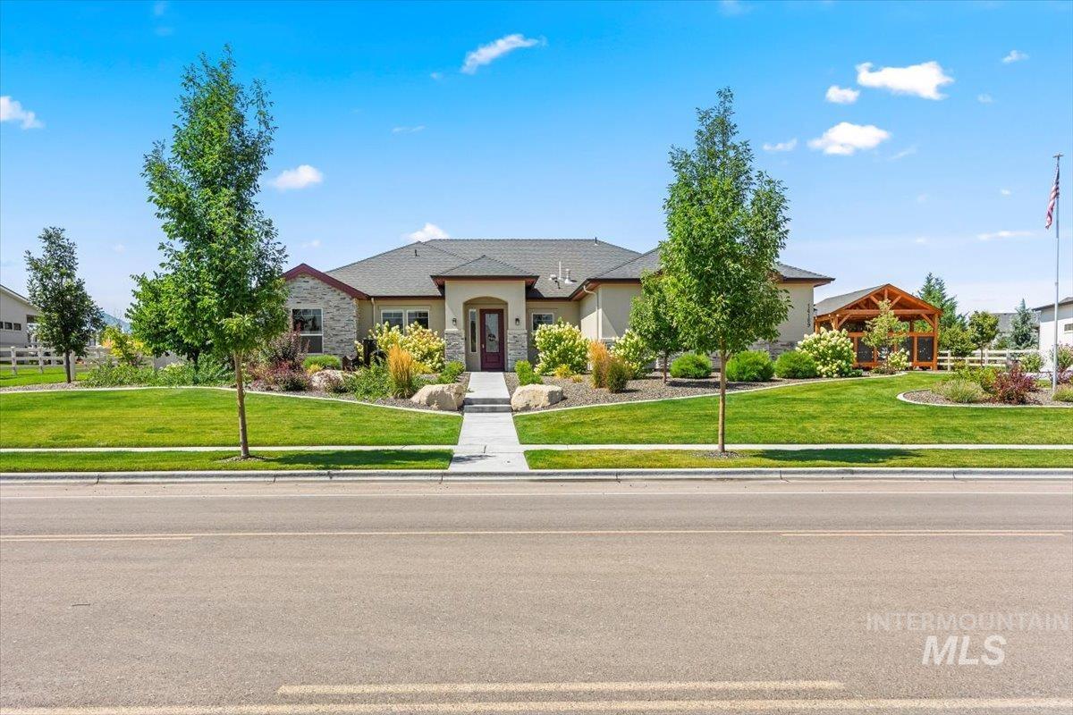 View of front of home featuring a front yard, stucco siding, and stone siding