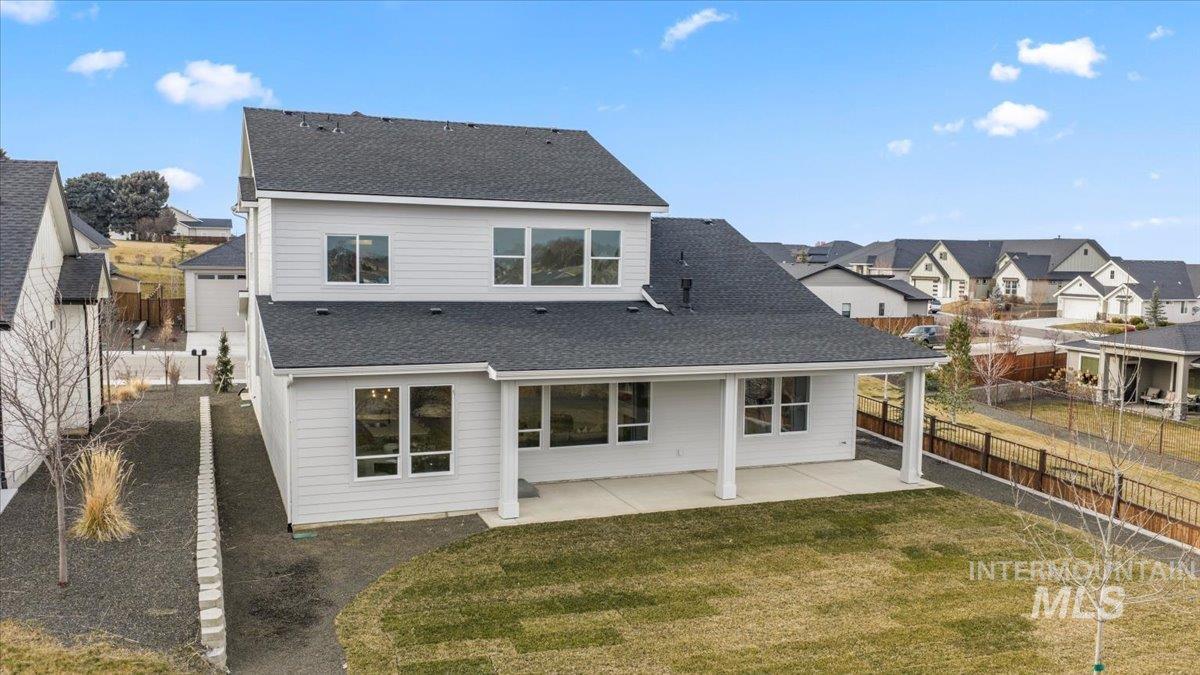 Back of house with a patio area, a shingled roof, a residential view, and a fenced backyard