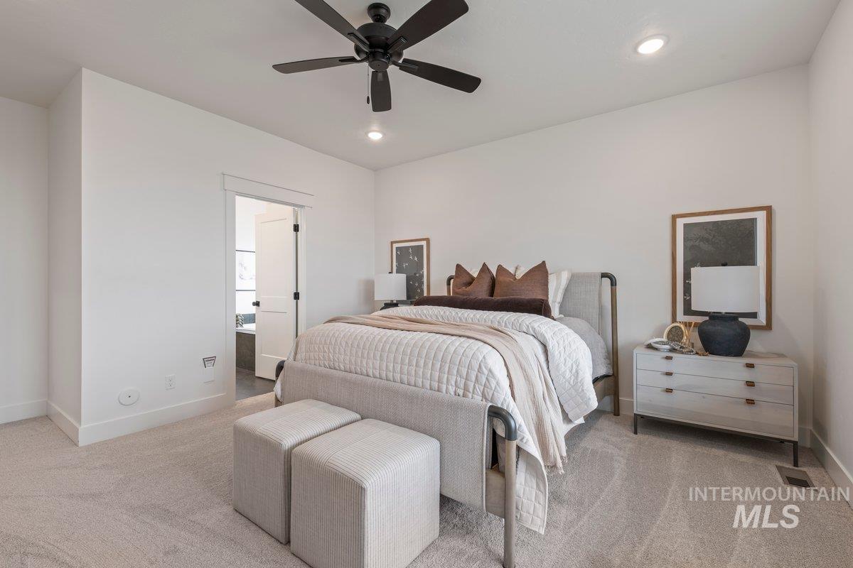 Bedroom featuring light colored carpet, ceiling fan, recessed lighting, and connected bathroom