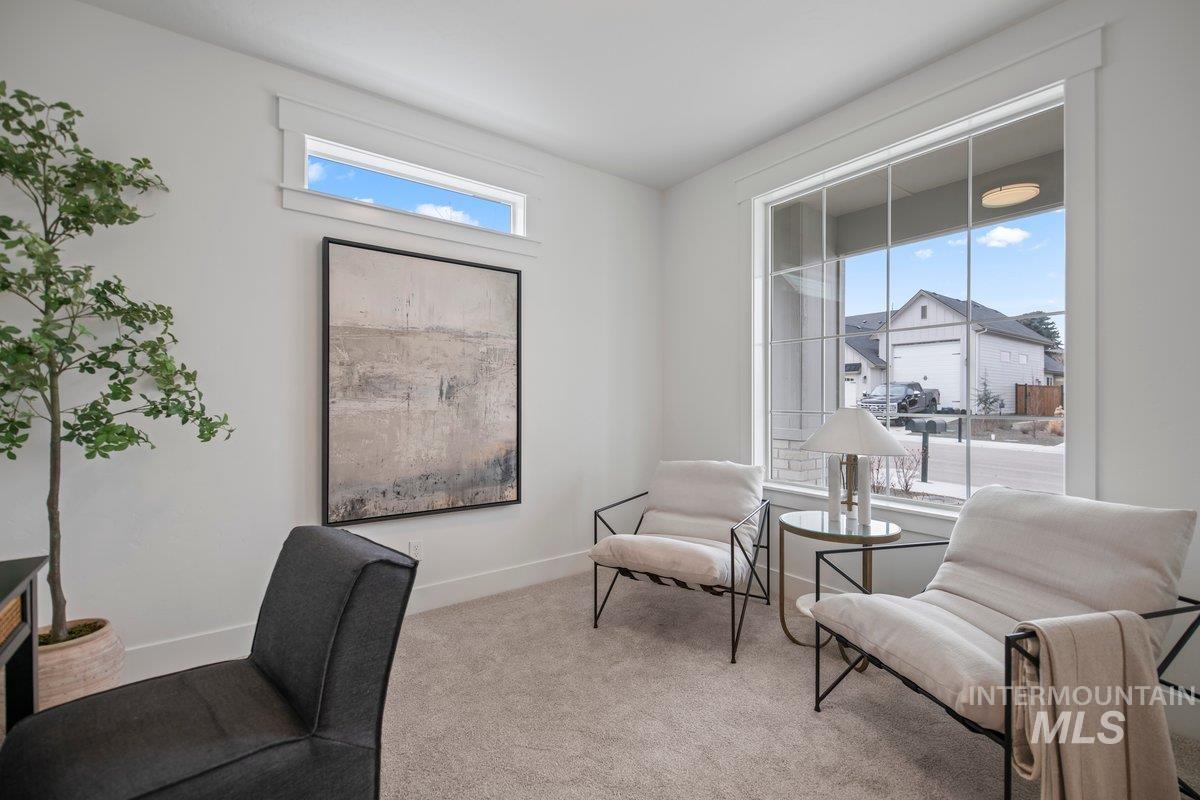 Living area featuring carpet flooring and baseboards