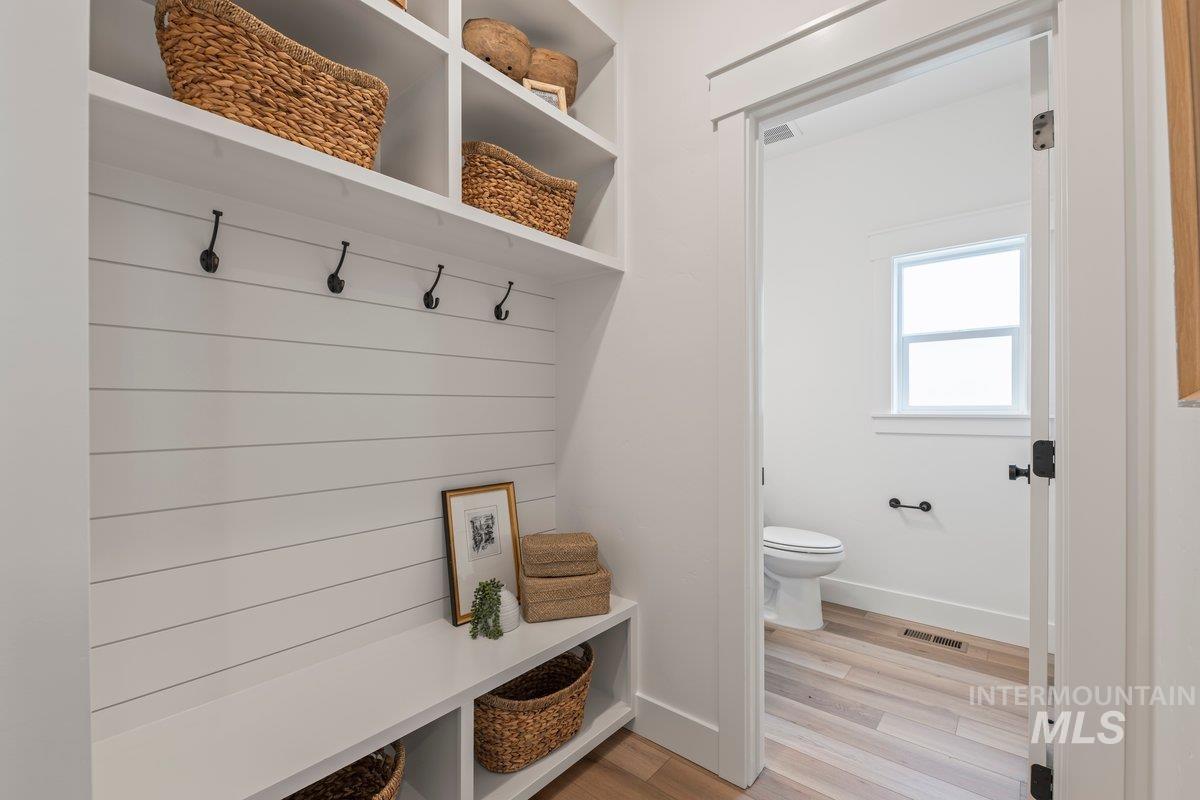 Mudroom featuring light wood-style flooring and baseboards