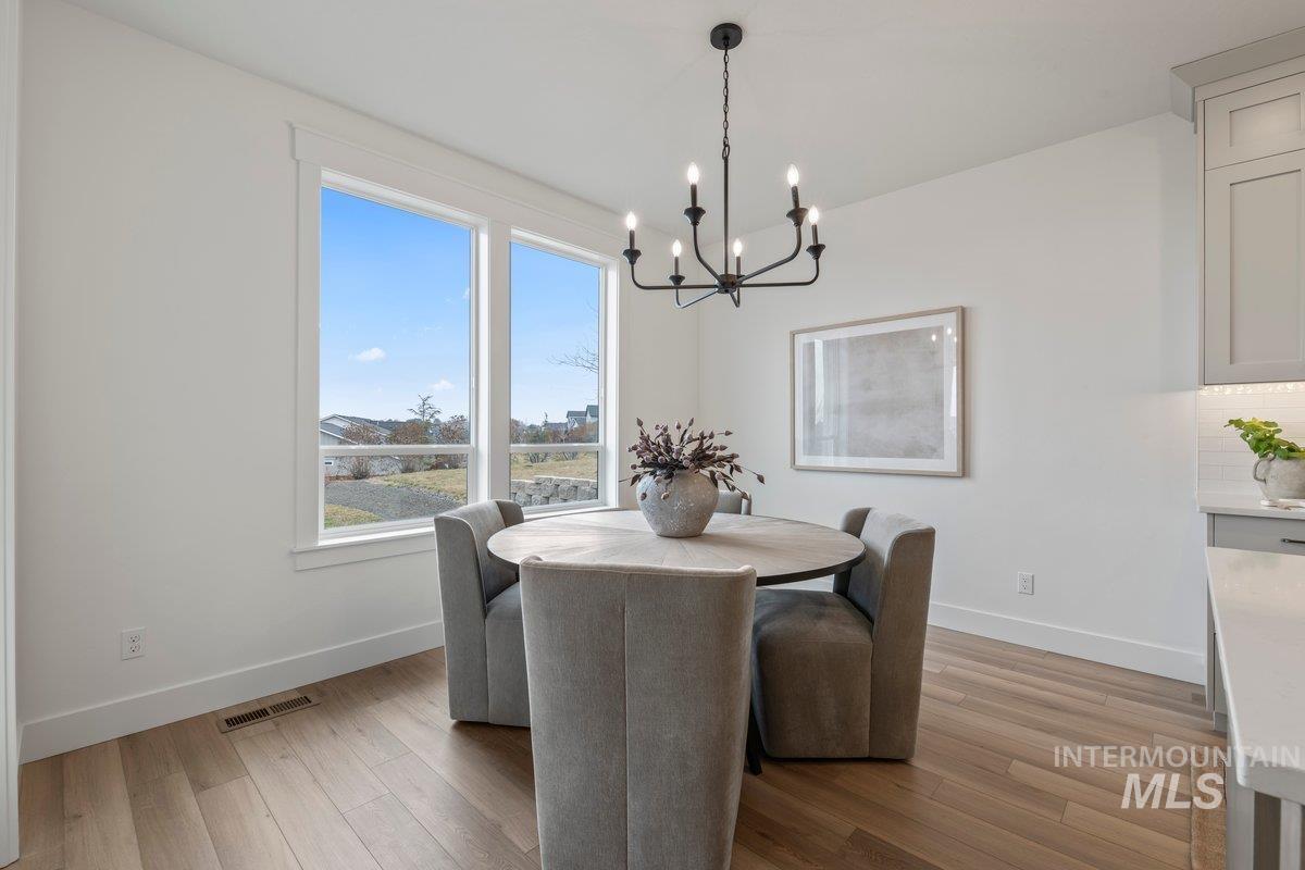 Dining space featuring light wood-type flooring and a chandelier