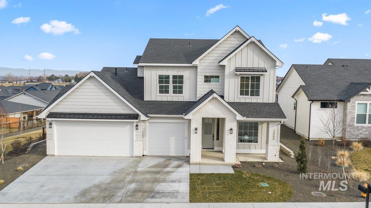 View of front of property with board and batten siding, driveway, roof with shingles, and covered porch