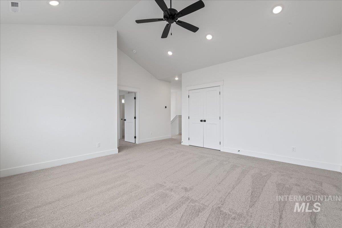 Unfurnished bedroom with high vaulted ceiling, light carpet, ceiling fan, recessed lighting, and a closet