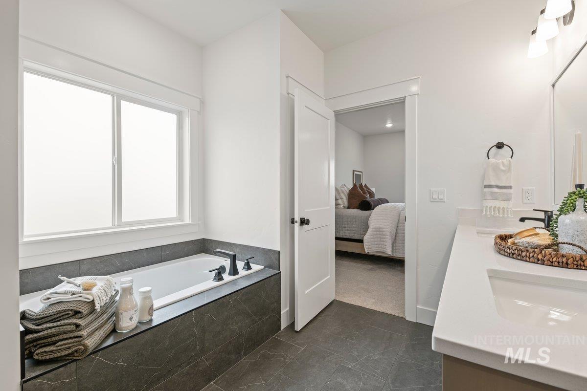 Bathroom with ensuite bath, double vanity, and a bath