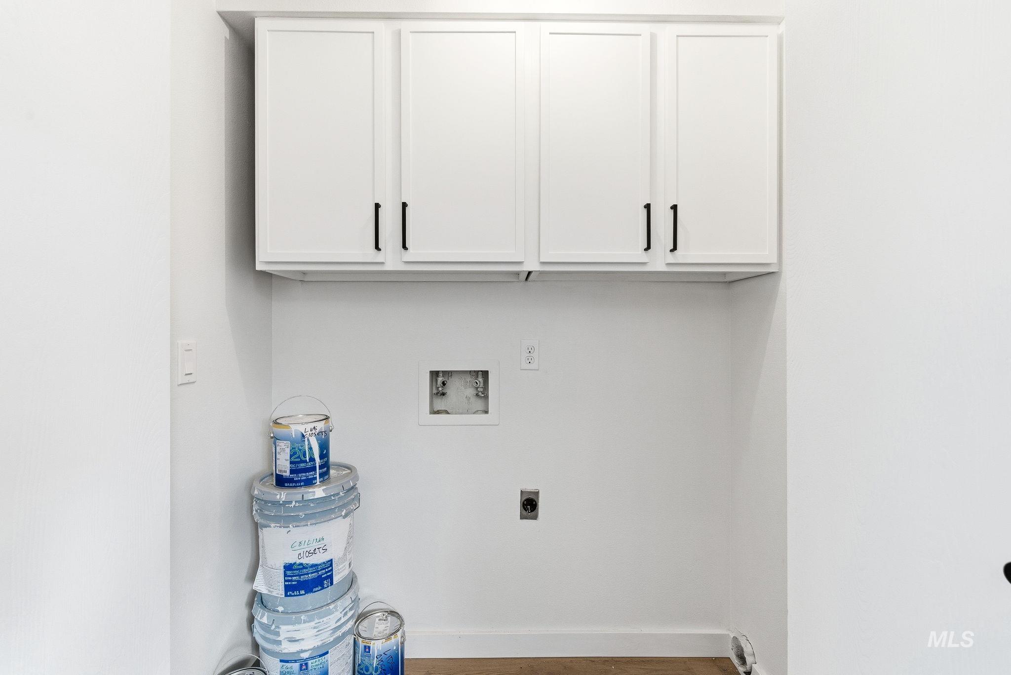 Laundry area featuring washer hookup, light wood finished floors, hookup for an electric dryer, and cabinet space