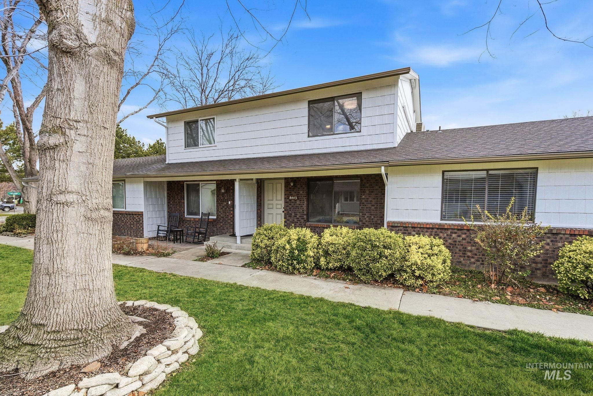 Traditional-style house with a front lawn, a shingled roof, covered porch, and brick siding