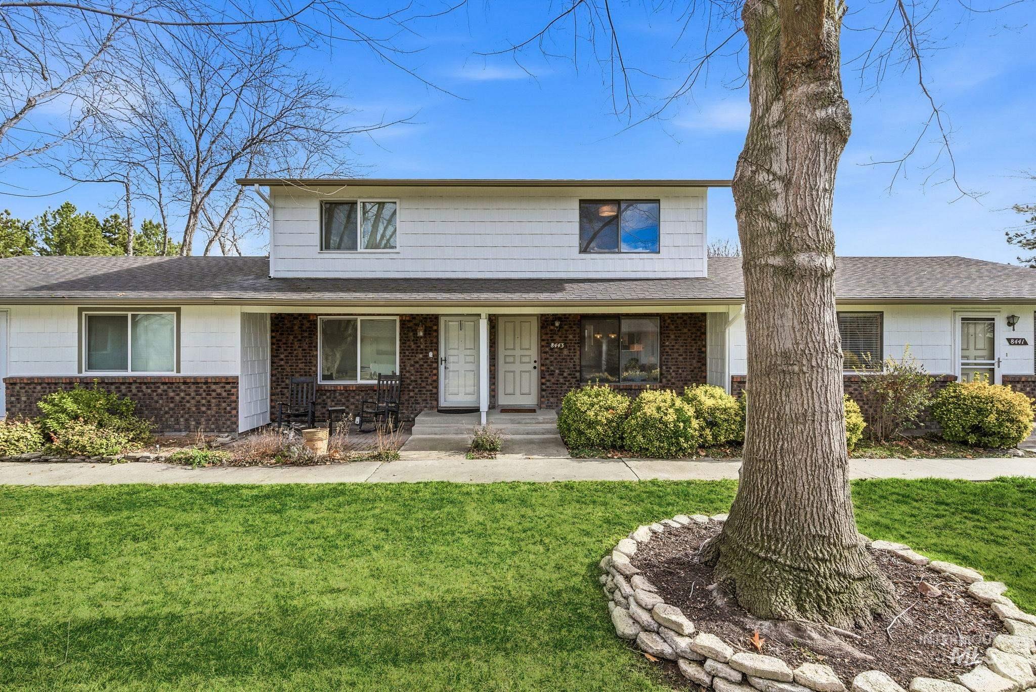 Traditional home featuring a front yard, a porch, roof with shingles, and brick siding