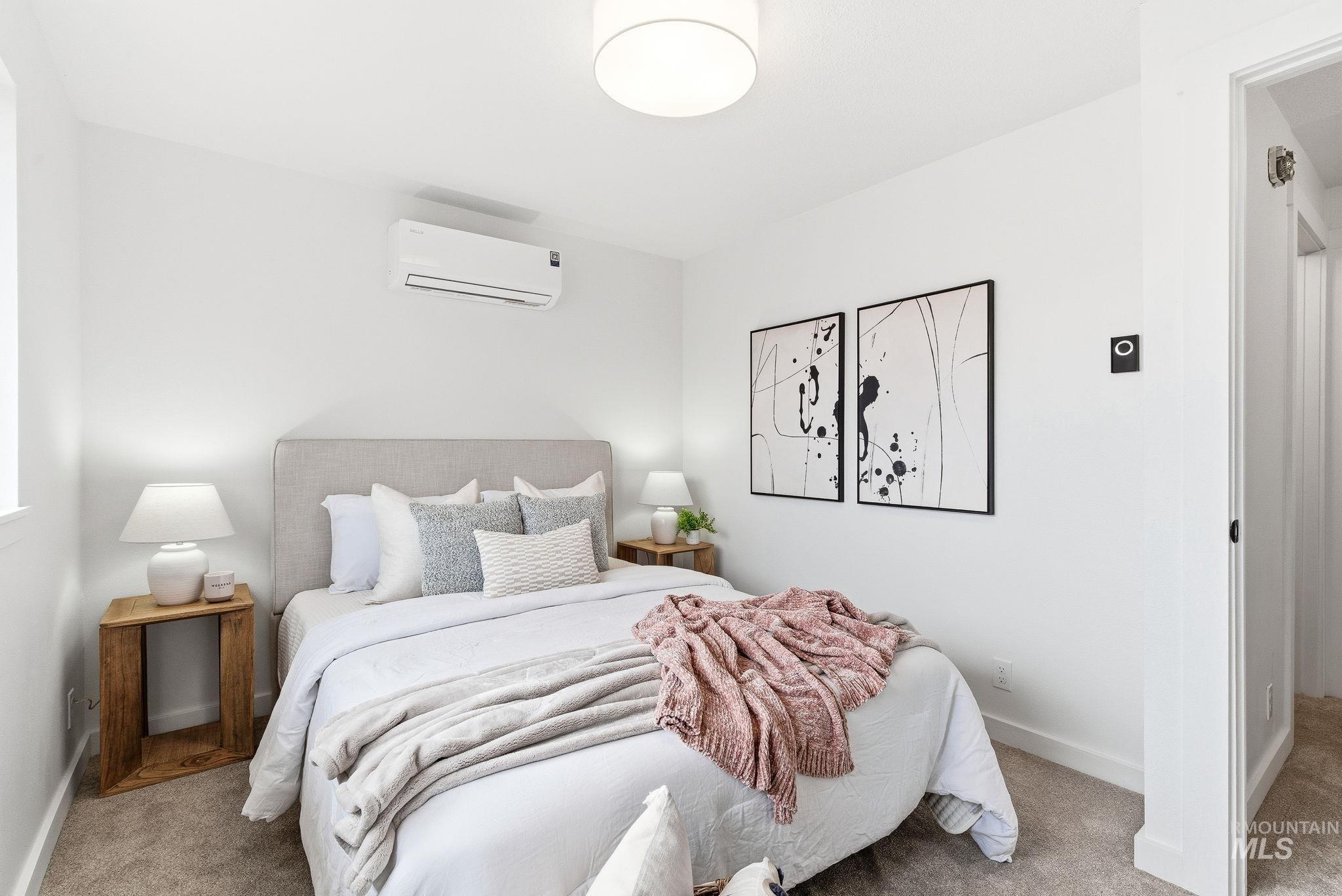 Carpeted bedroom featuring a wall mounted mini split and baseboards