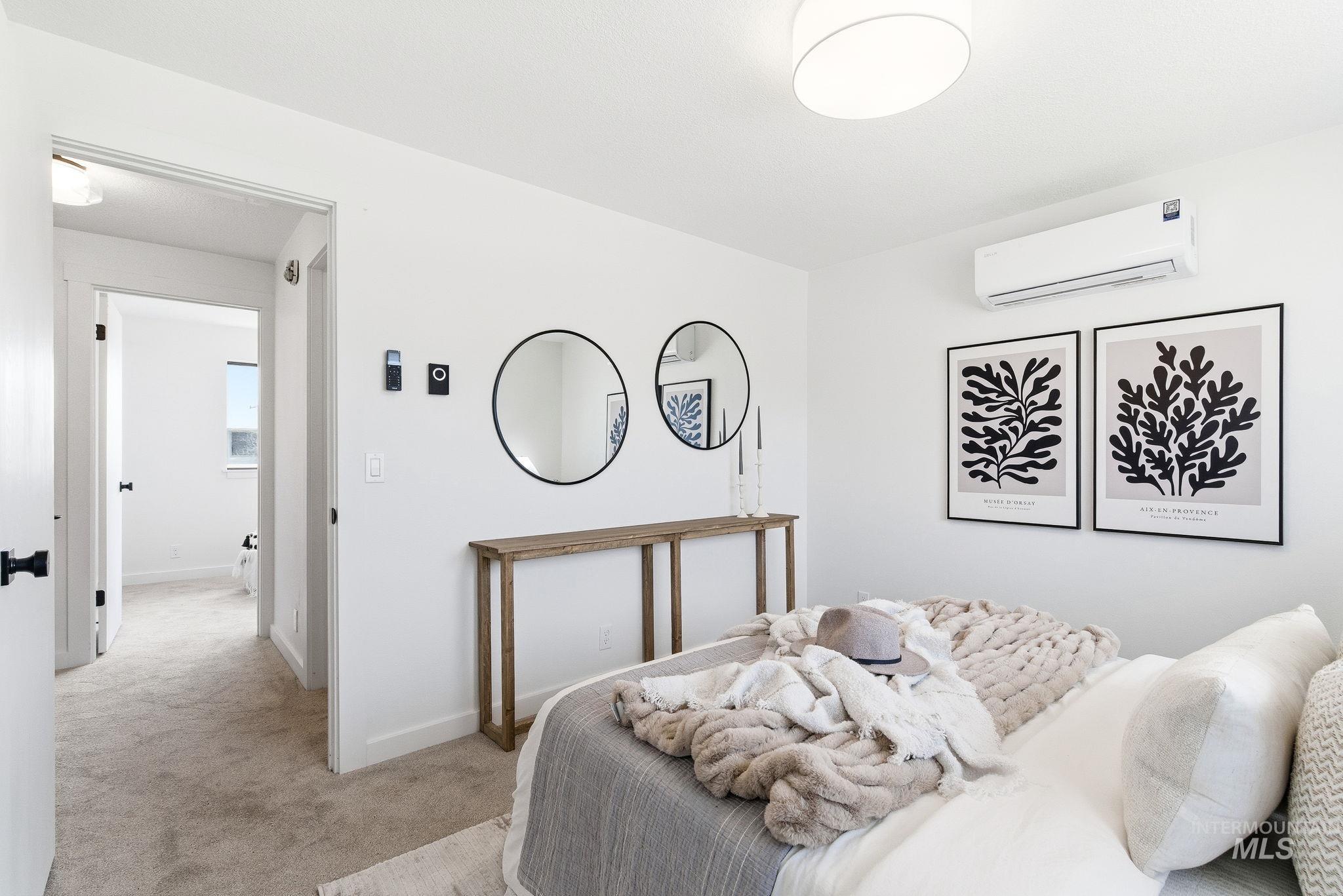 Bedroom with light carpet and a mini split for heating / cooling