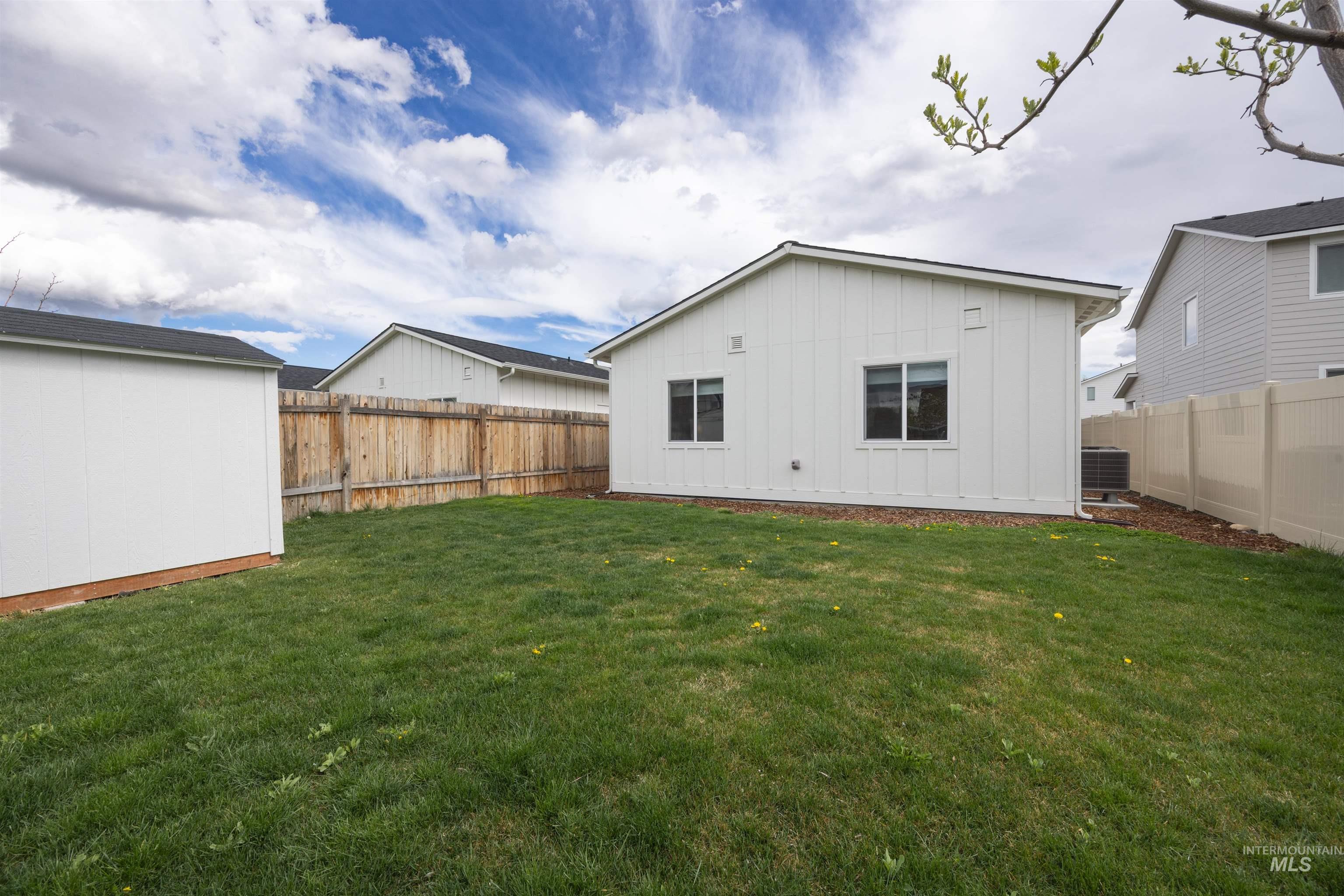 Expansive green lawn with a wooden privacy fence bordering the property