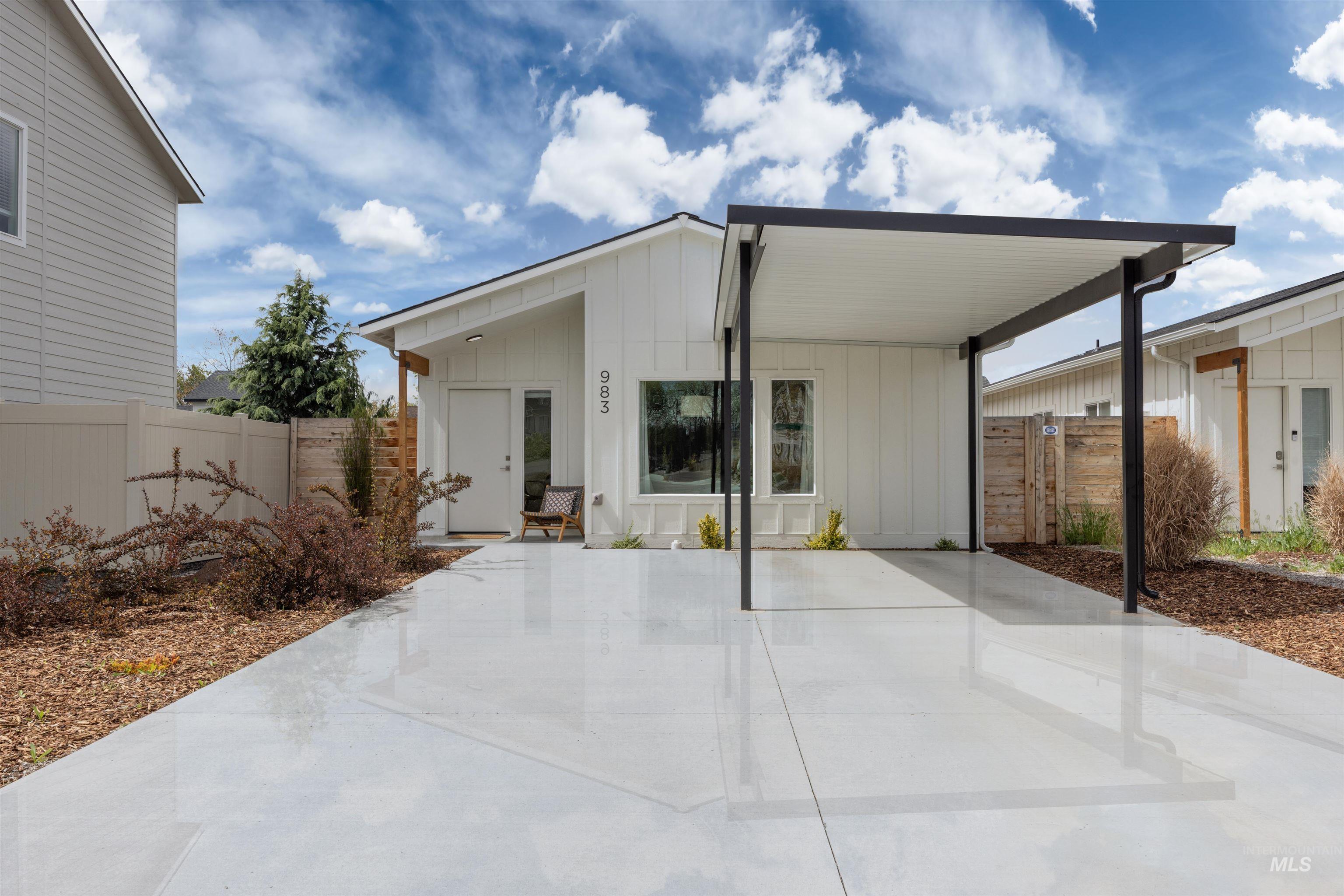 View of front of property featuring board and batten siding, a gate, and an attached carport