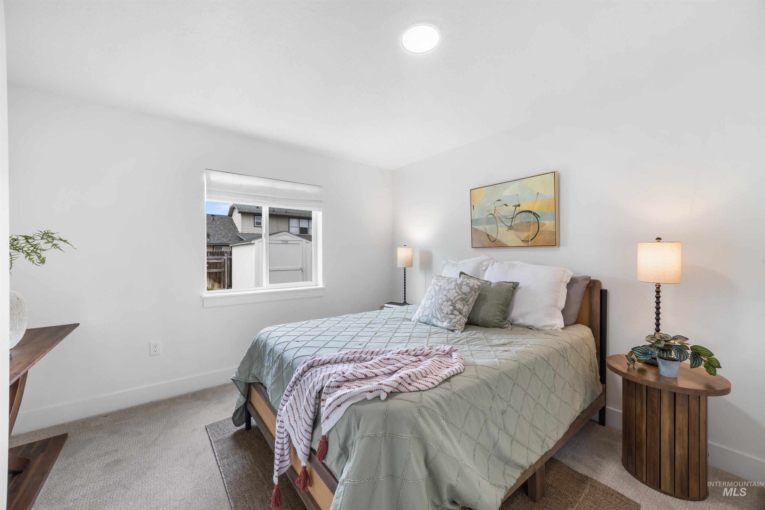 Bedroom featuring a single window with white trim, recessed ceiling lighting, and light-toned carpeting