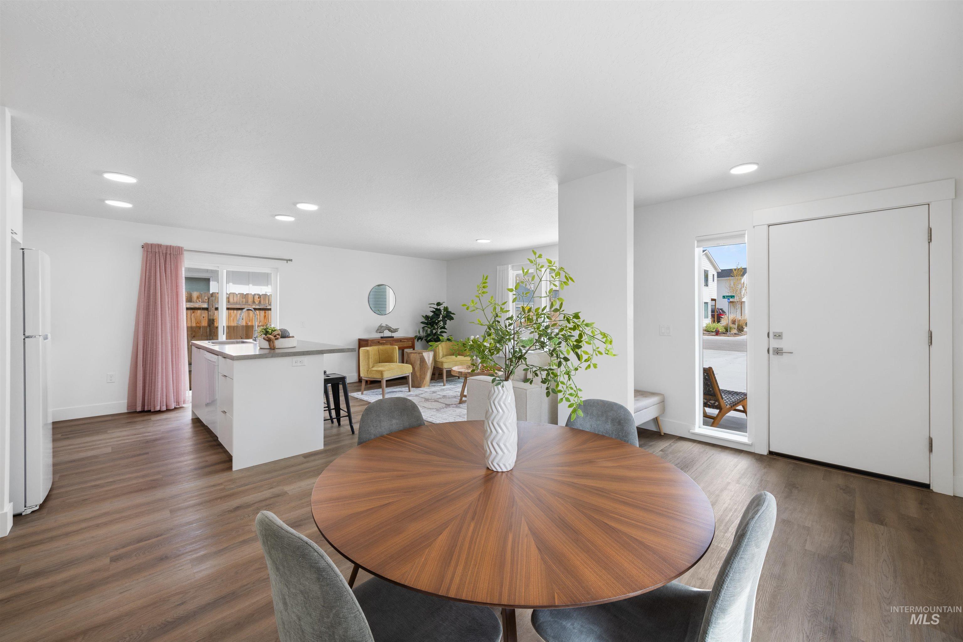 Open-concept living space with wood-finish flooring, recessed lighting, and a white kitchen island