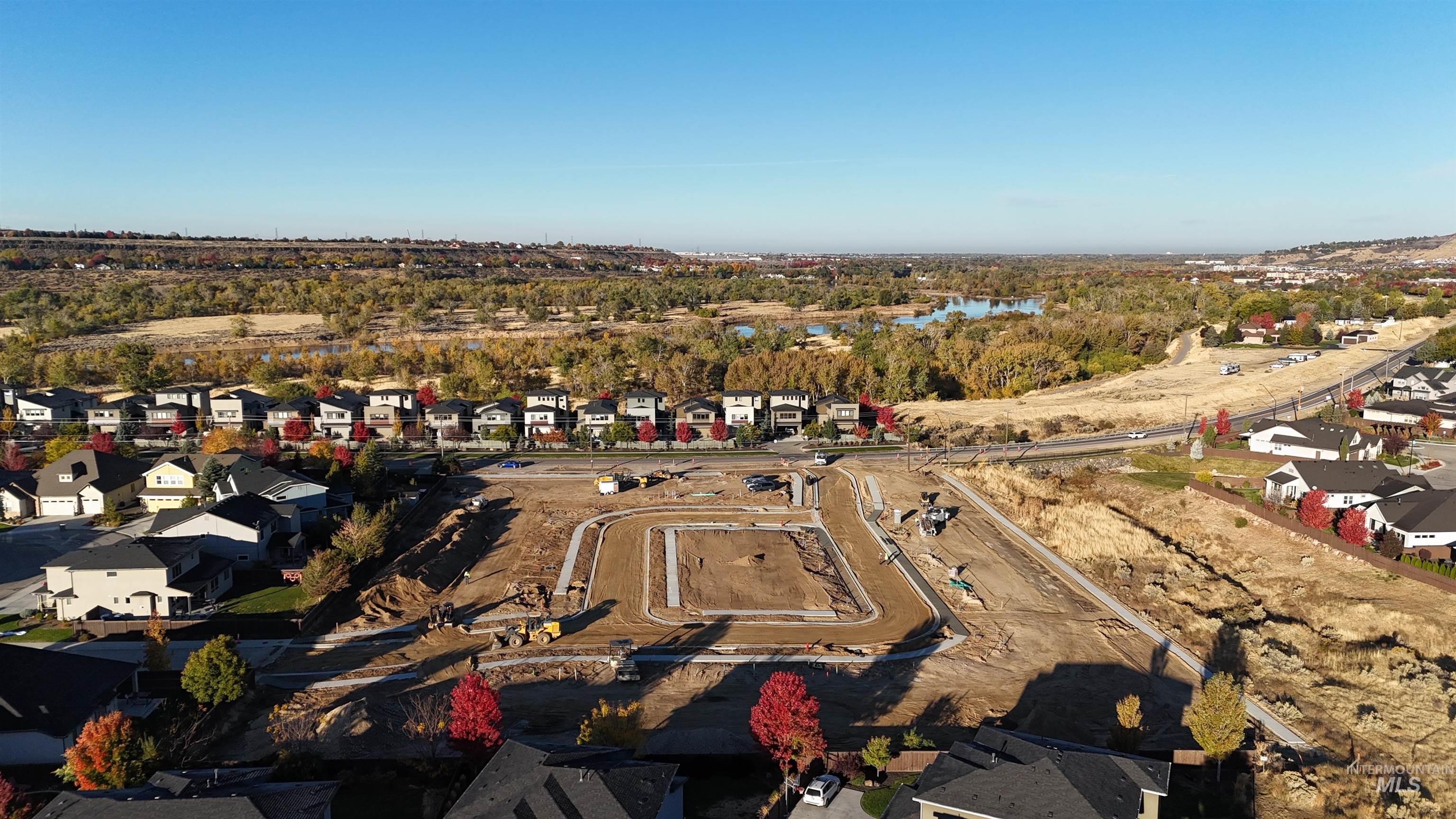Aerial view of property and surrounding area featuring nearby suburban area and a nearby body of water