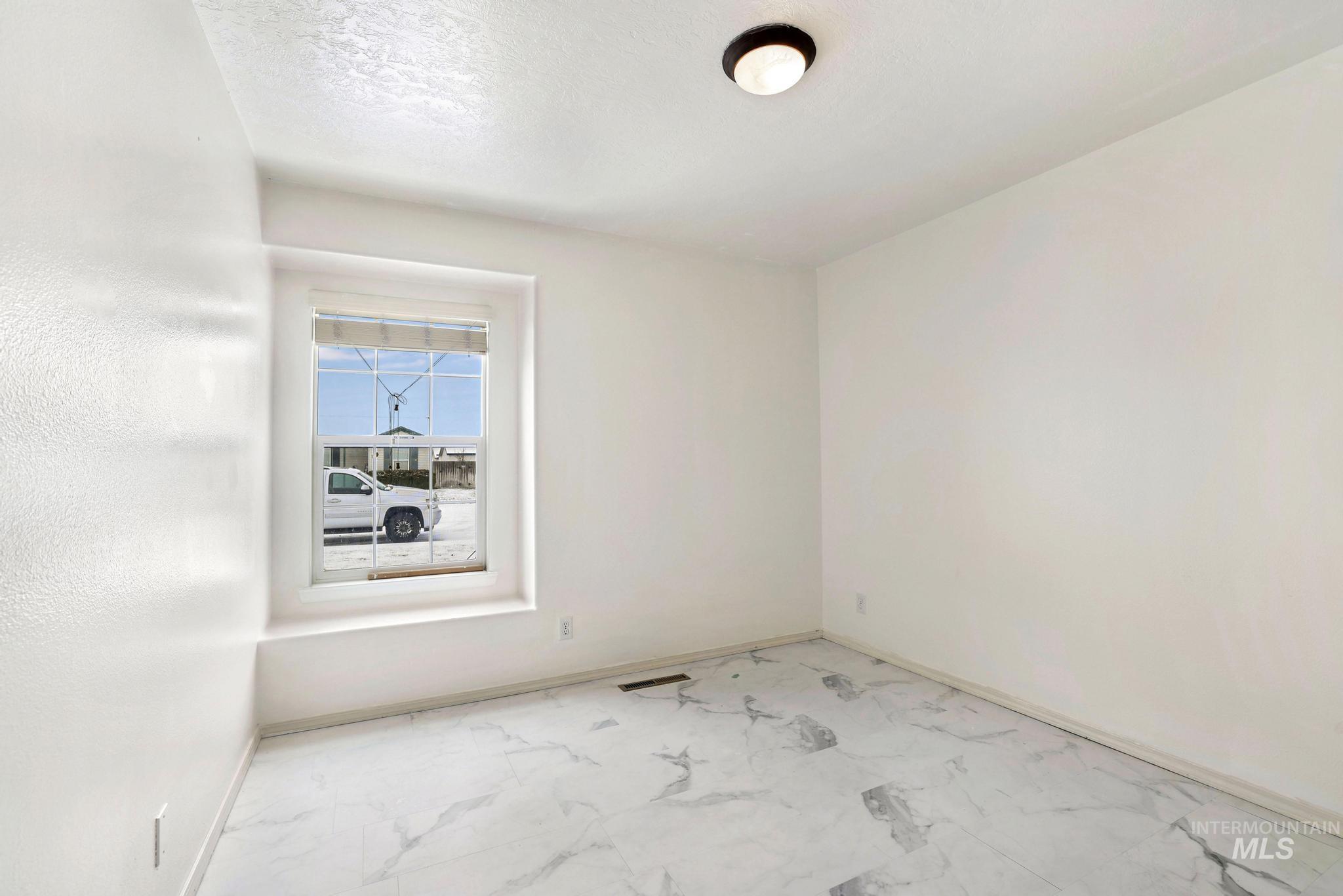 Empty room with marble look tiles and baseboards