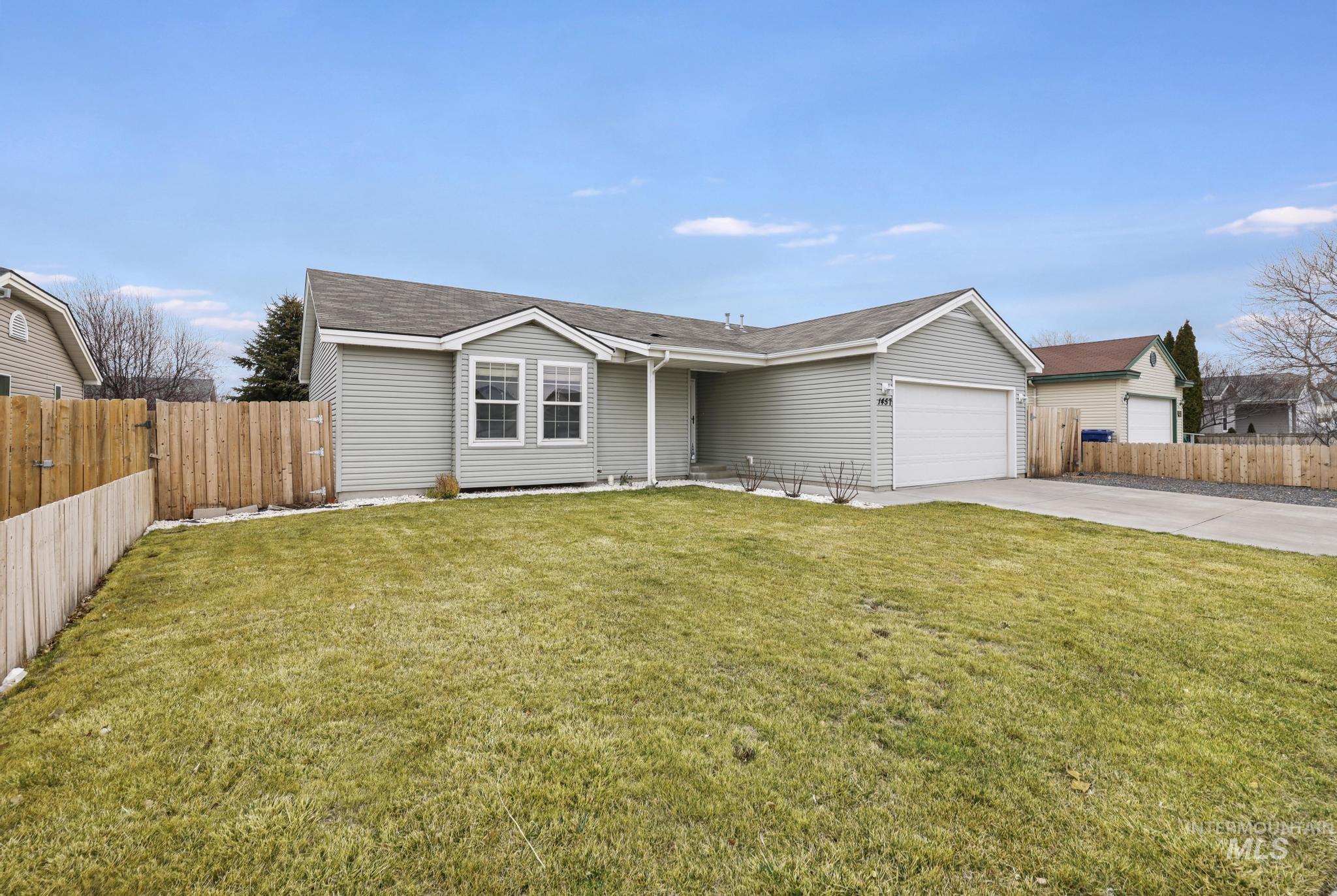 Ranch-style house featuring driveway and an attached garage