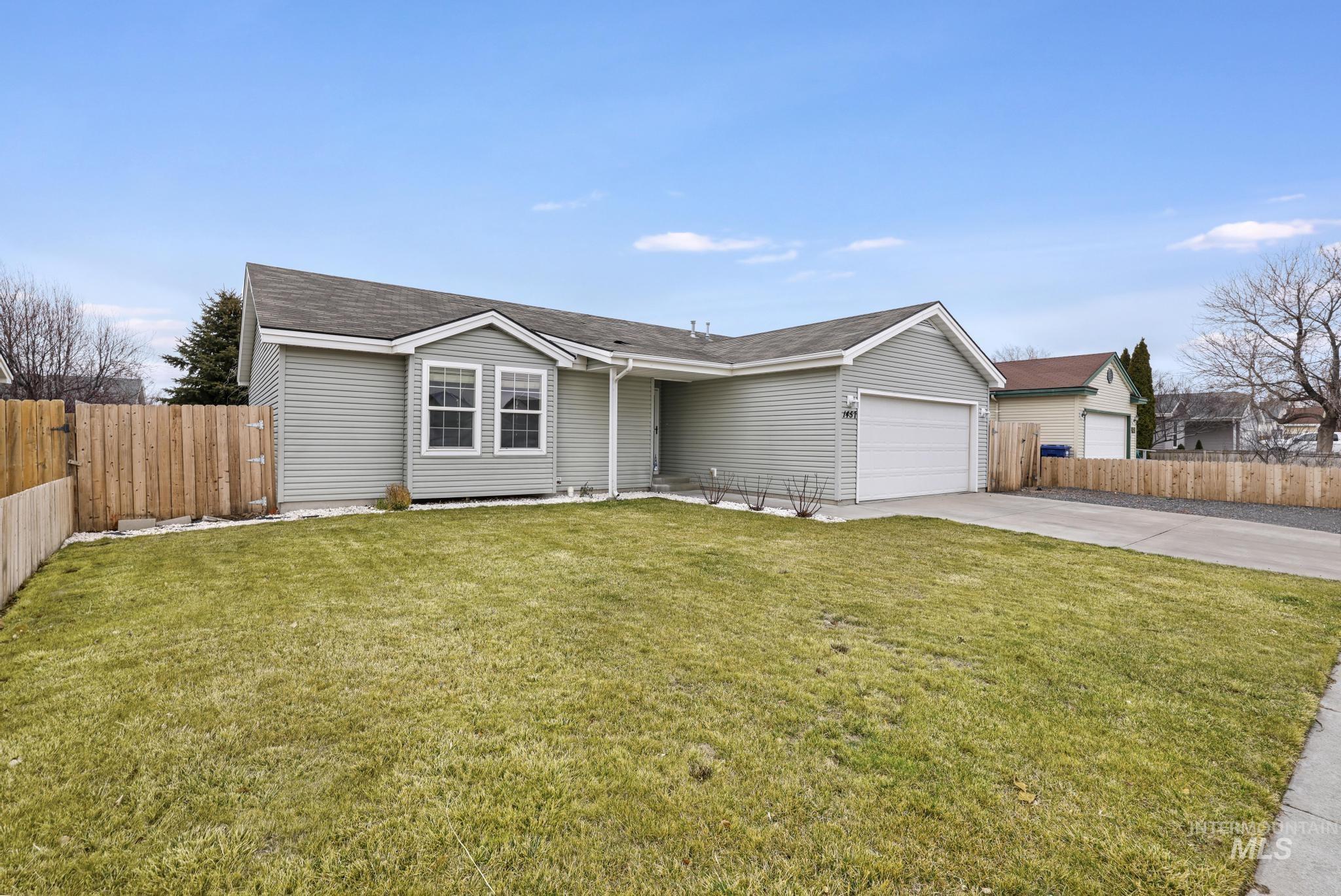 Ranch-style home featuring concrete driveway, a garage, and roof with shingles
