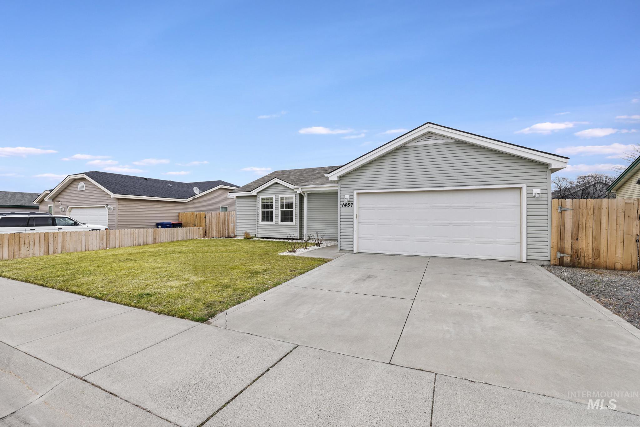 Ranch-style house featuring concrete driveway and an attached garage
