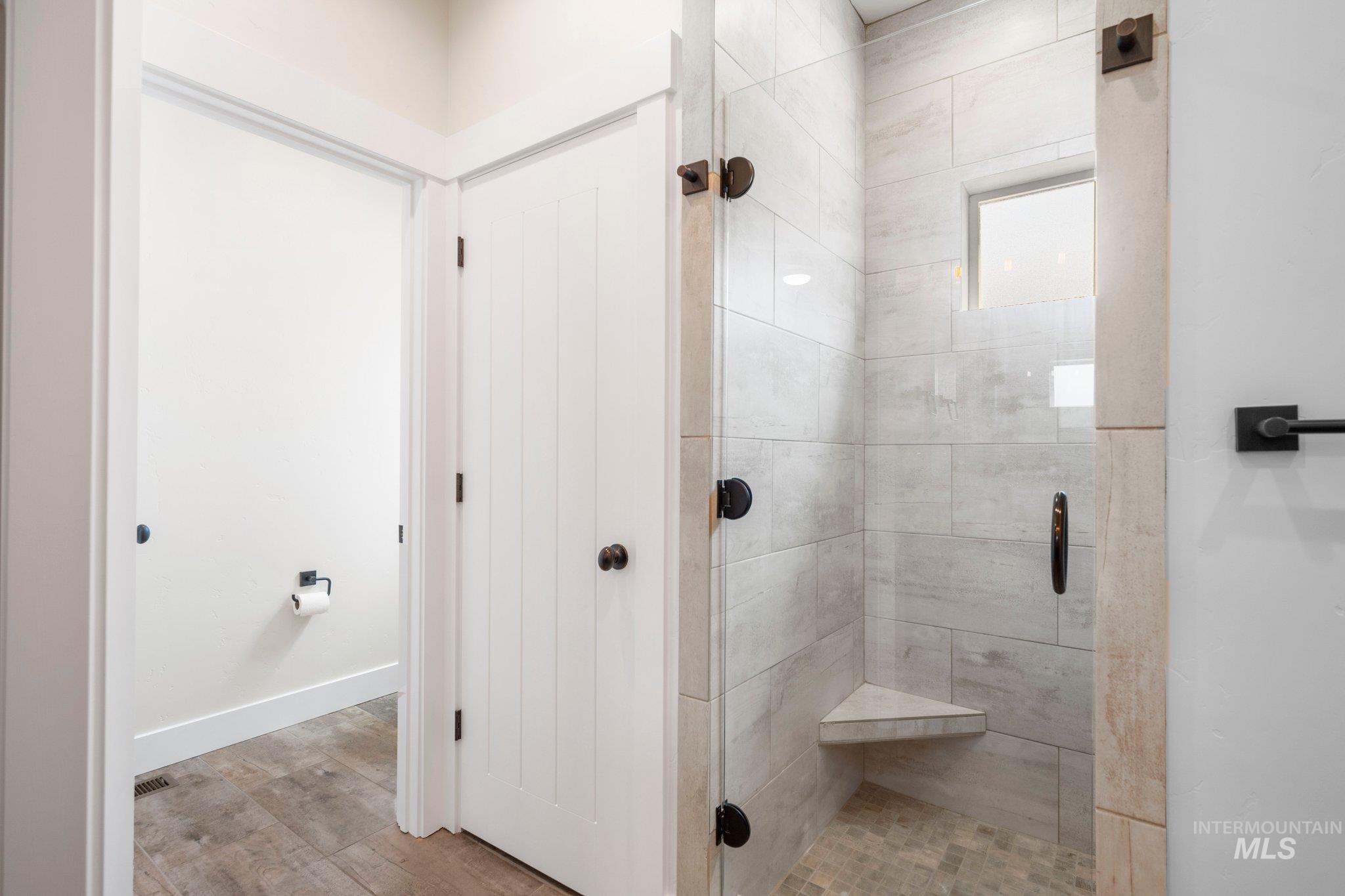 Bathroom featuring a shower stall and wood finished floors