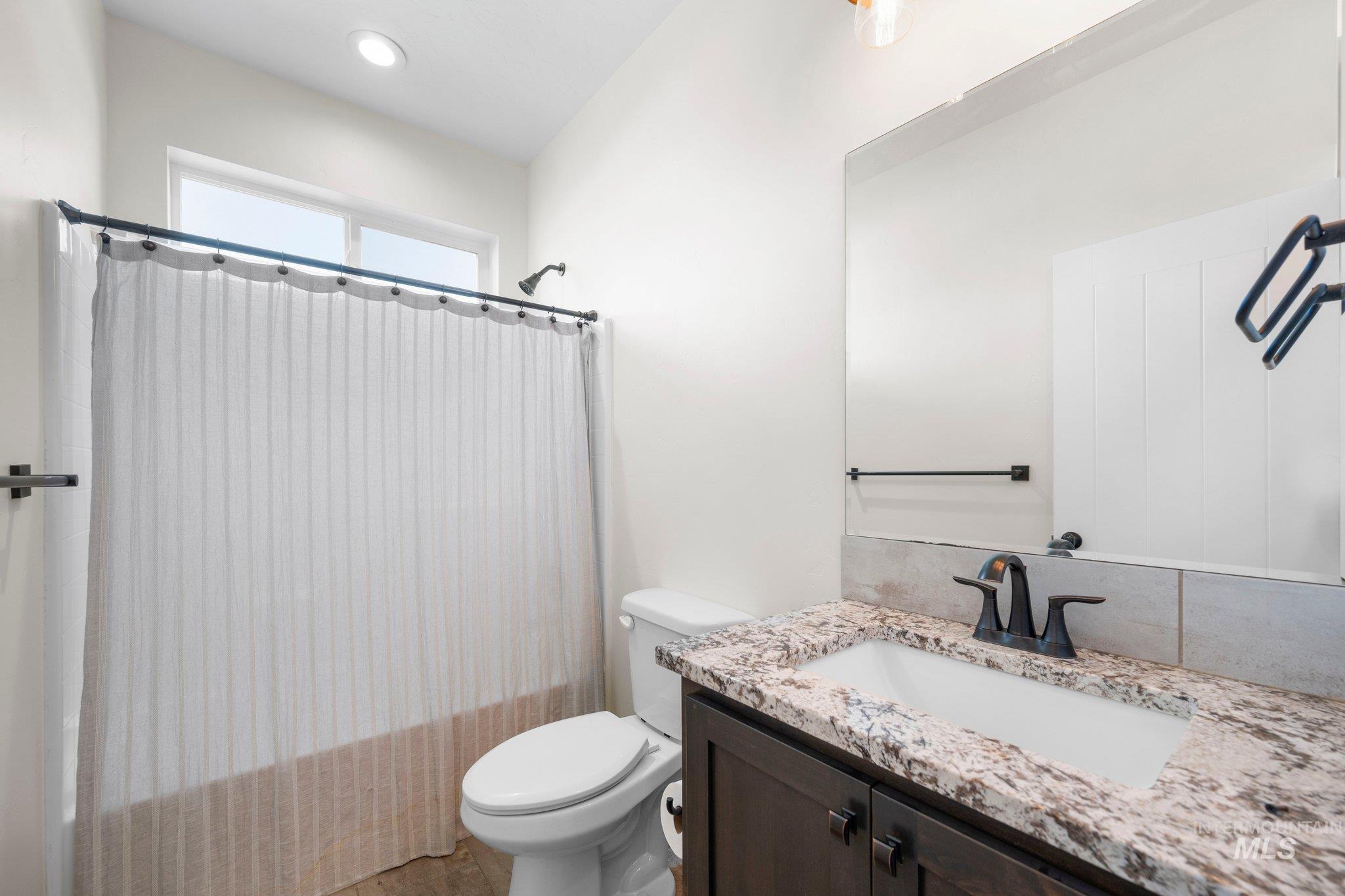 Full bath featuring vanity and shower / bathtub combination with curtain