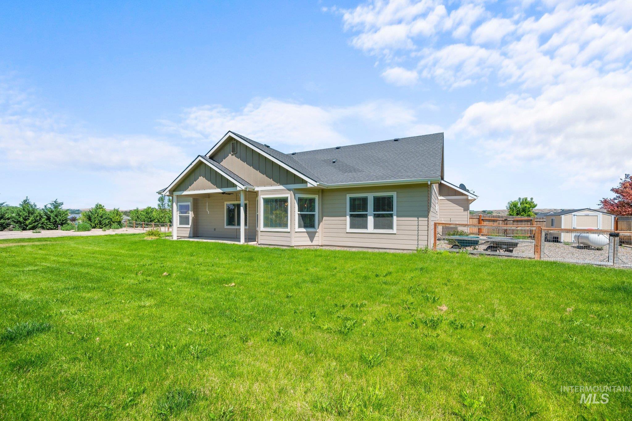 View of front of house with a shingled roof and board and batten siding