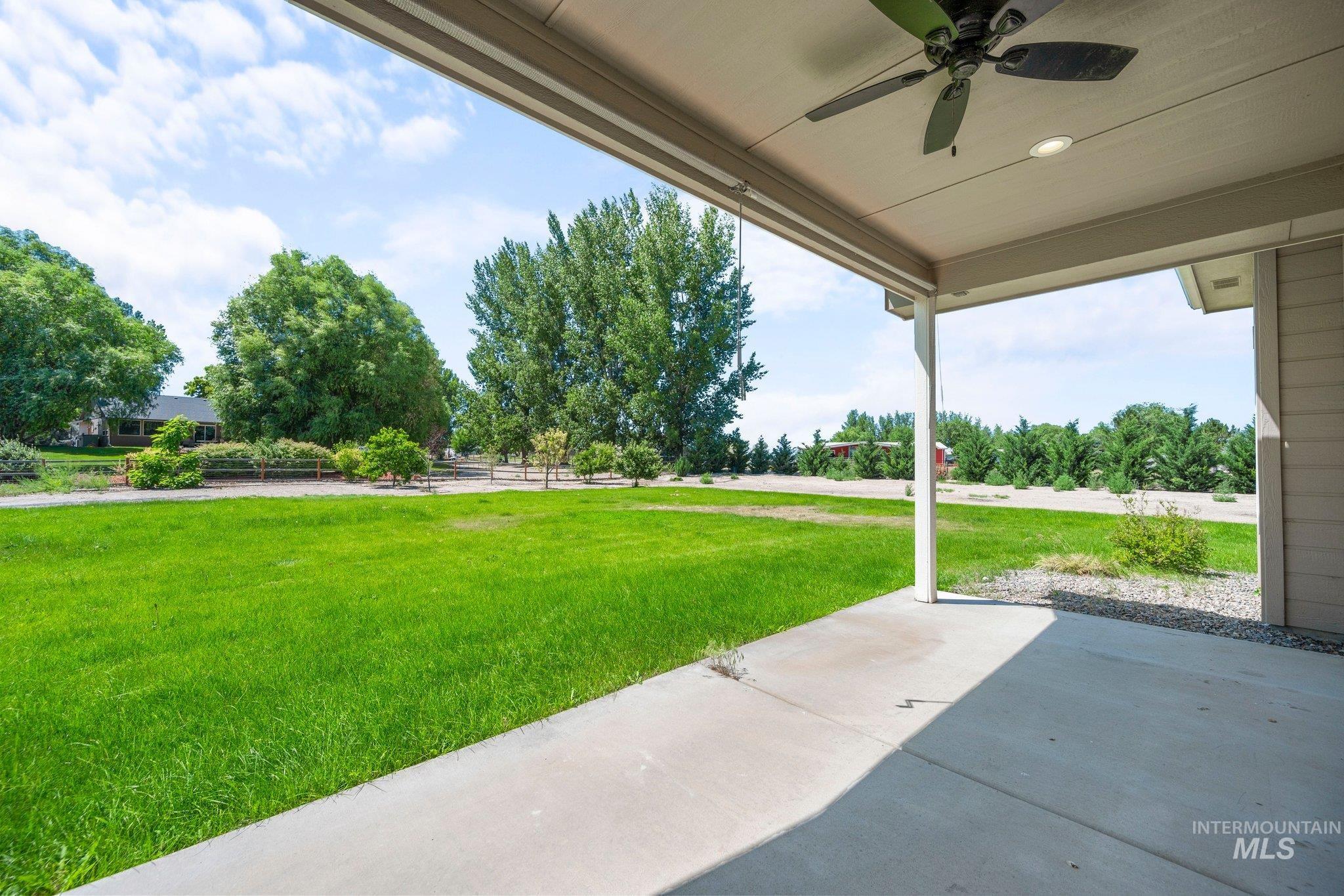View of yard with a ceiling fan and a patio area