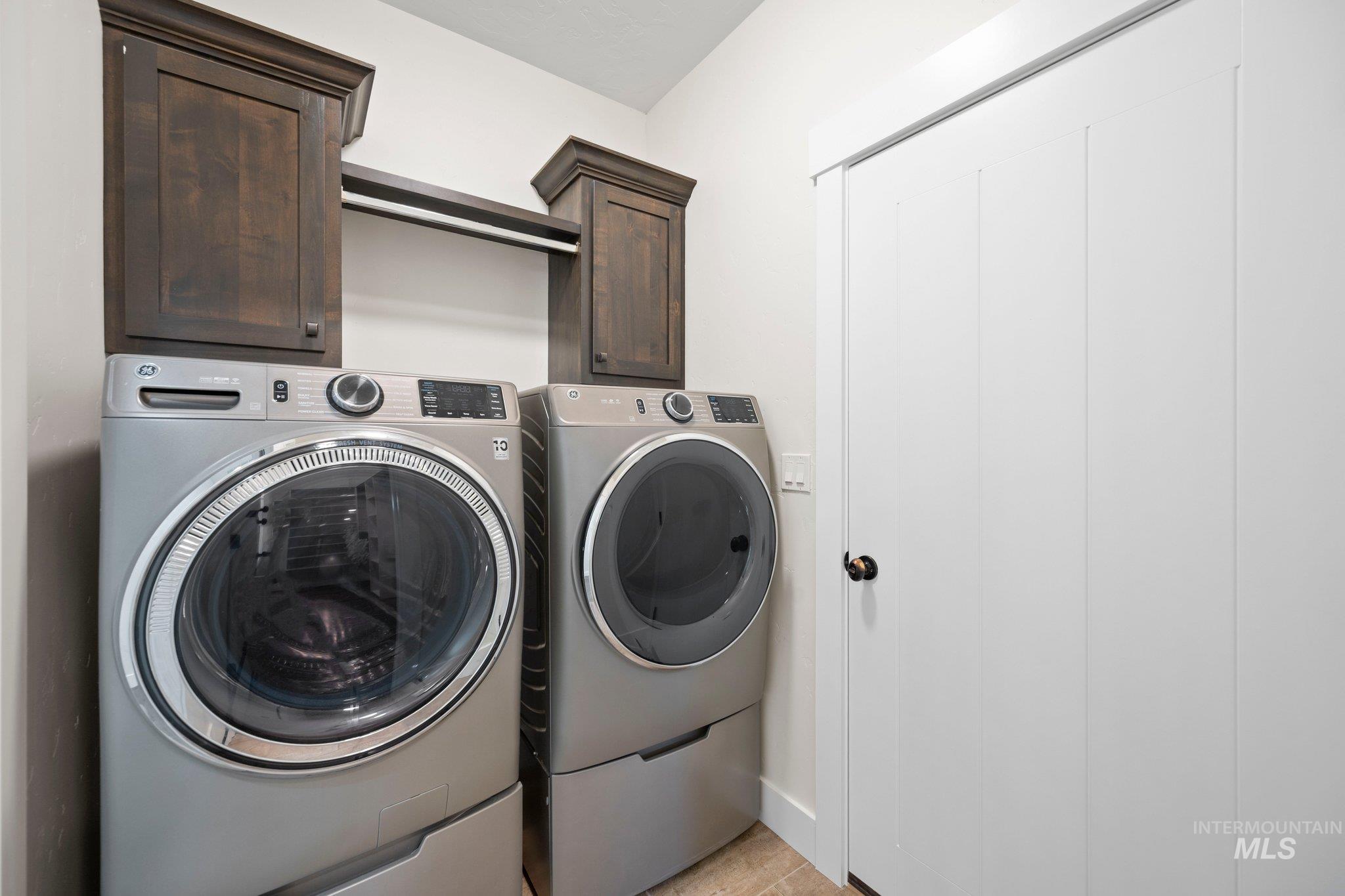 Laundry area featuring washing machine and clothes dryer and cabinet space
