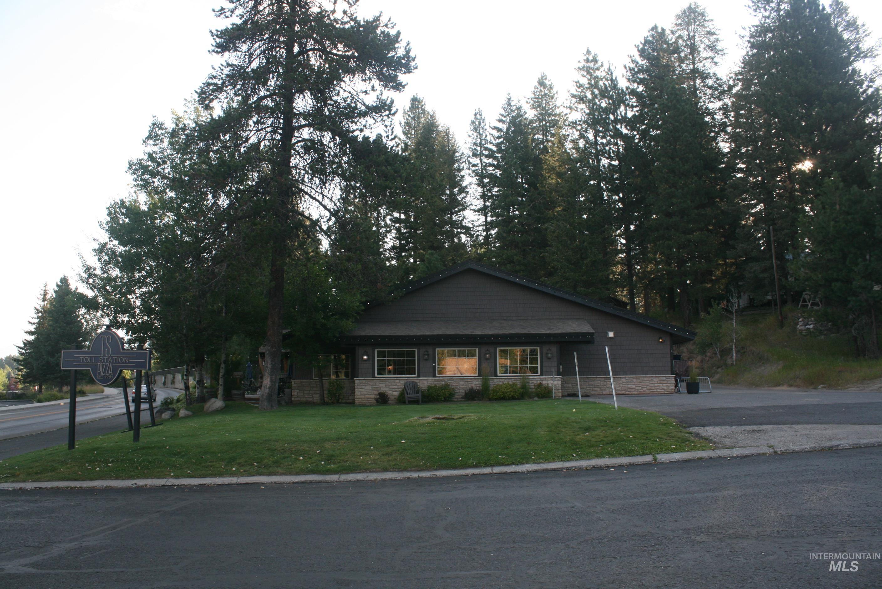 View of front of building with a front lawn and stone siding