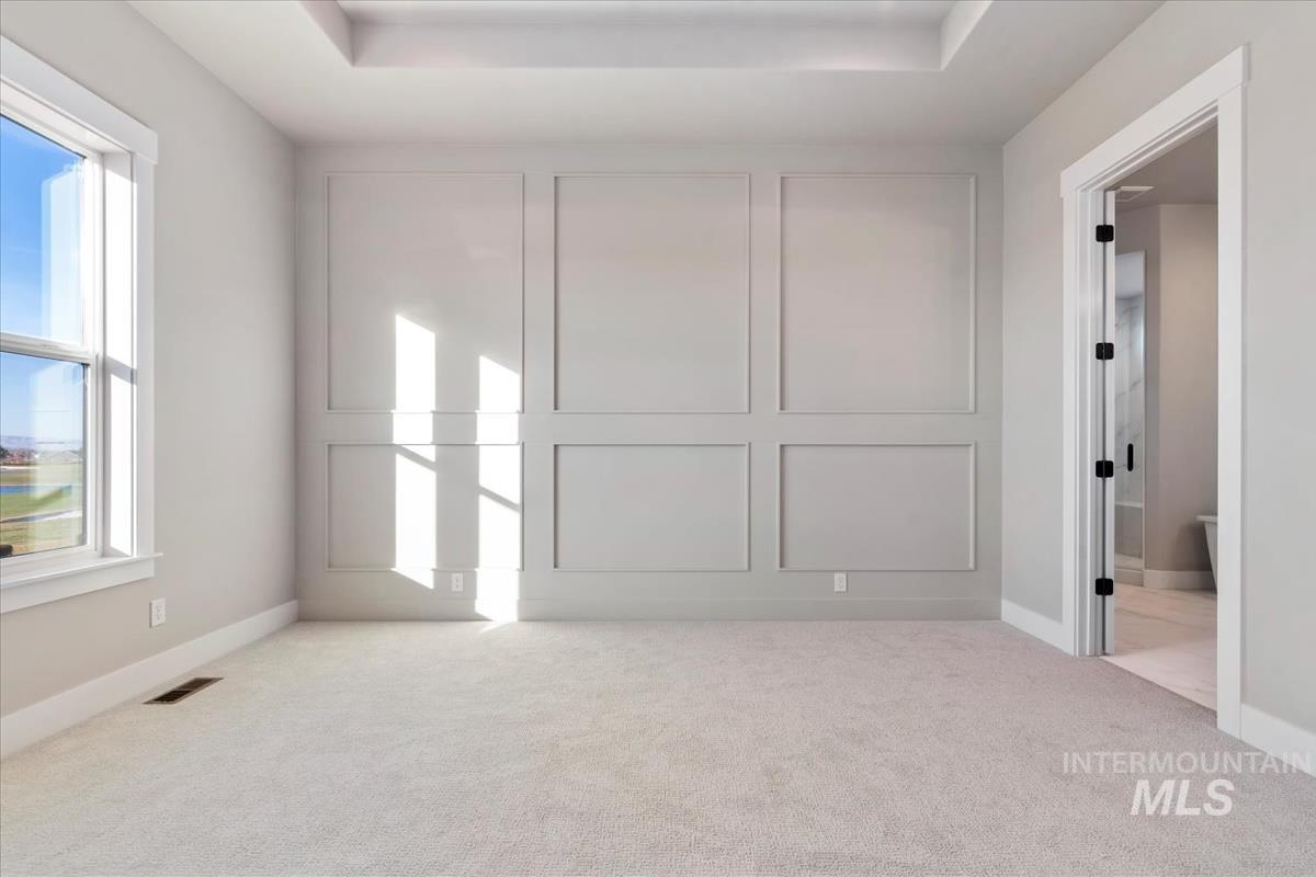 Spare room featuring light colored carpet and baseboards