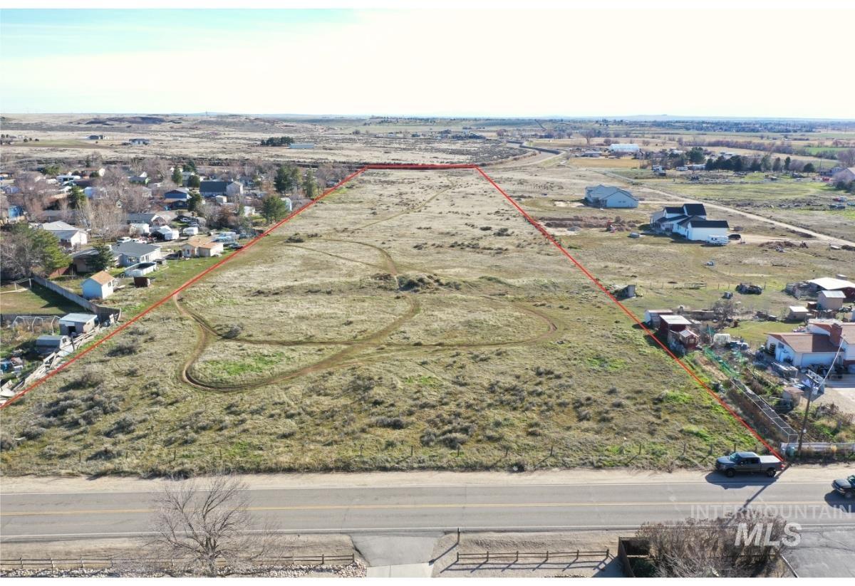 Overview of rural landscape with property parcel outlined and nearby suburban area