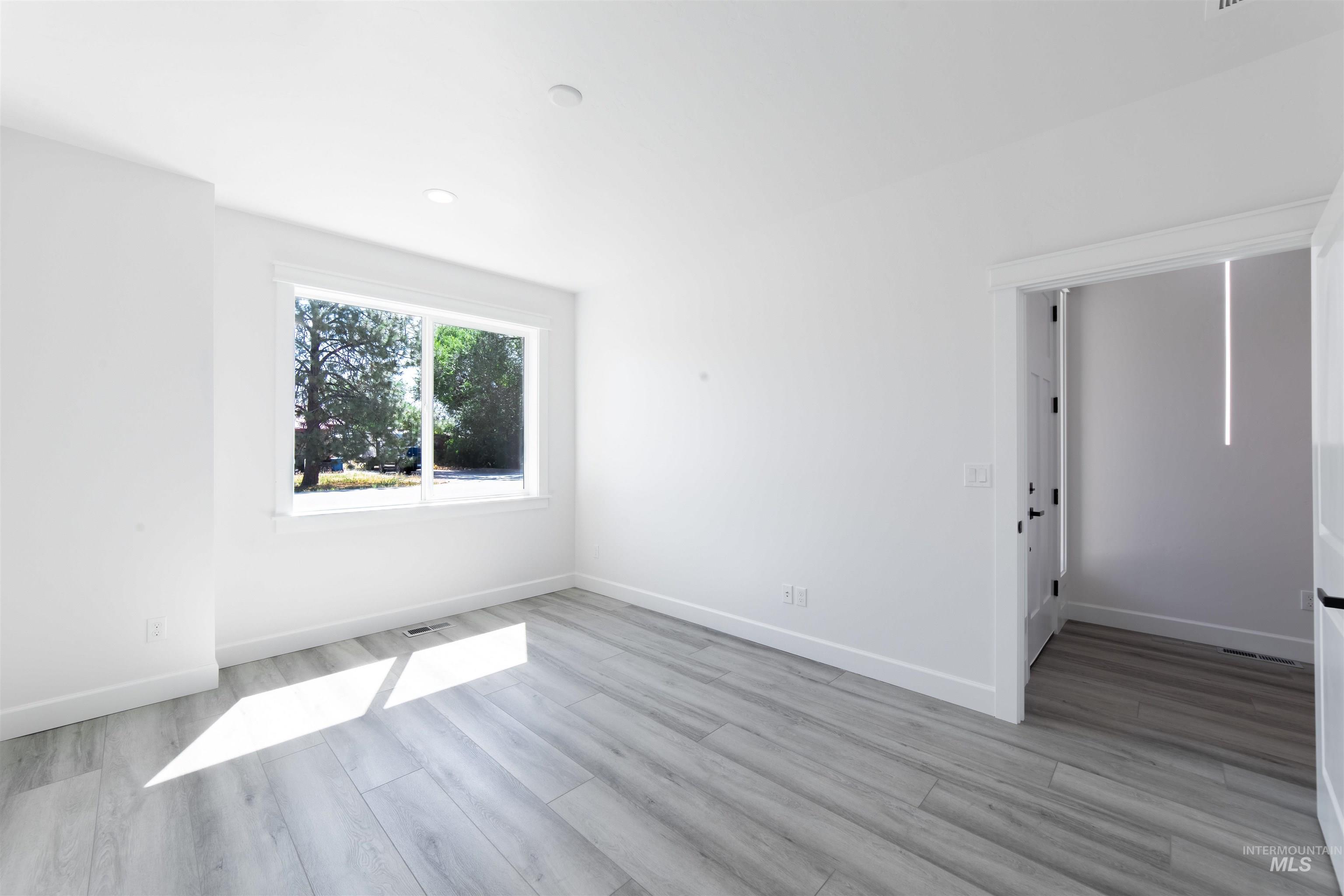 Empty room featuring light wood-style flooring and recessed lighting