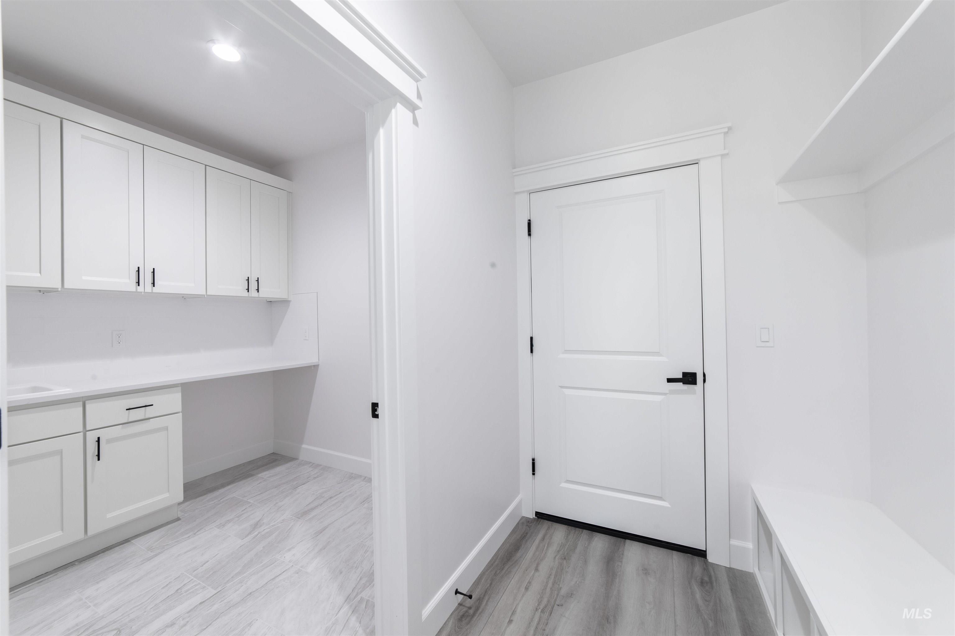 Washroom with light wood-type flooring and baseboards