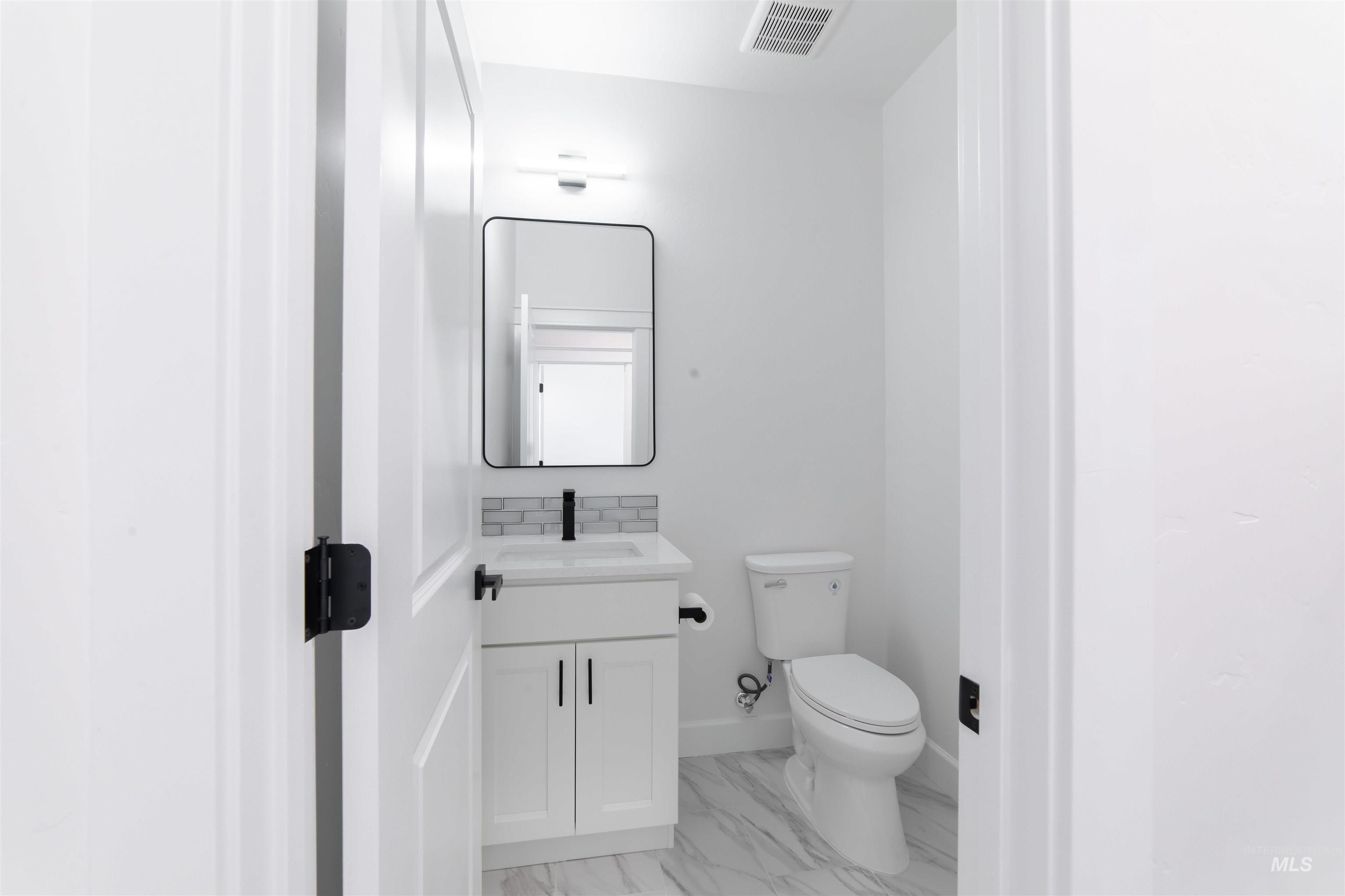 Bathroom with vanity and marble finish floors