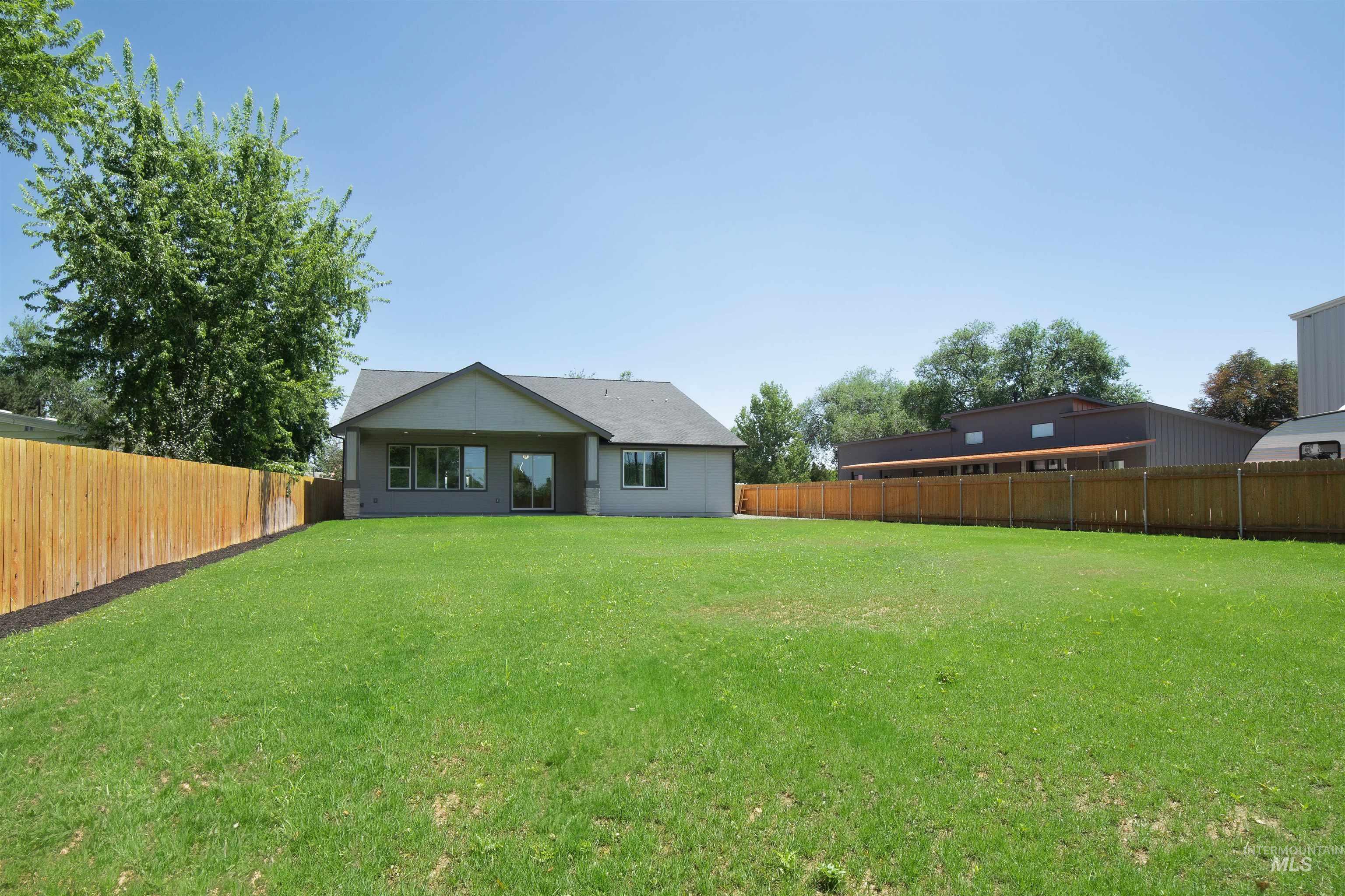 Rear view of house featuring a fenced backyard
